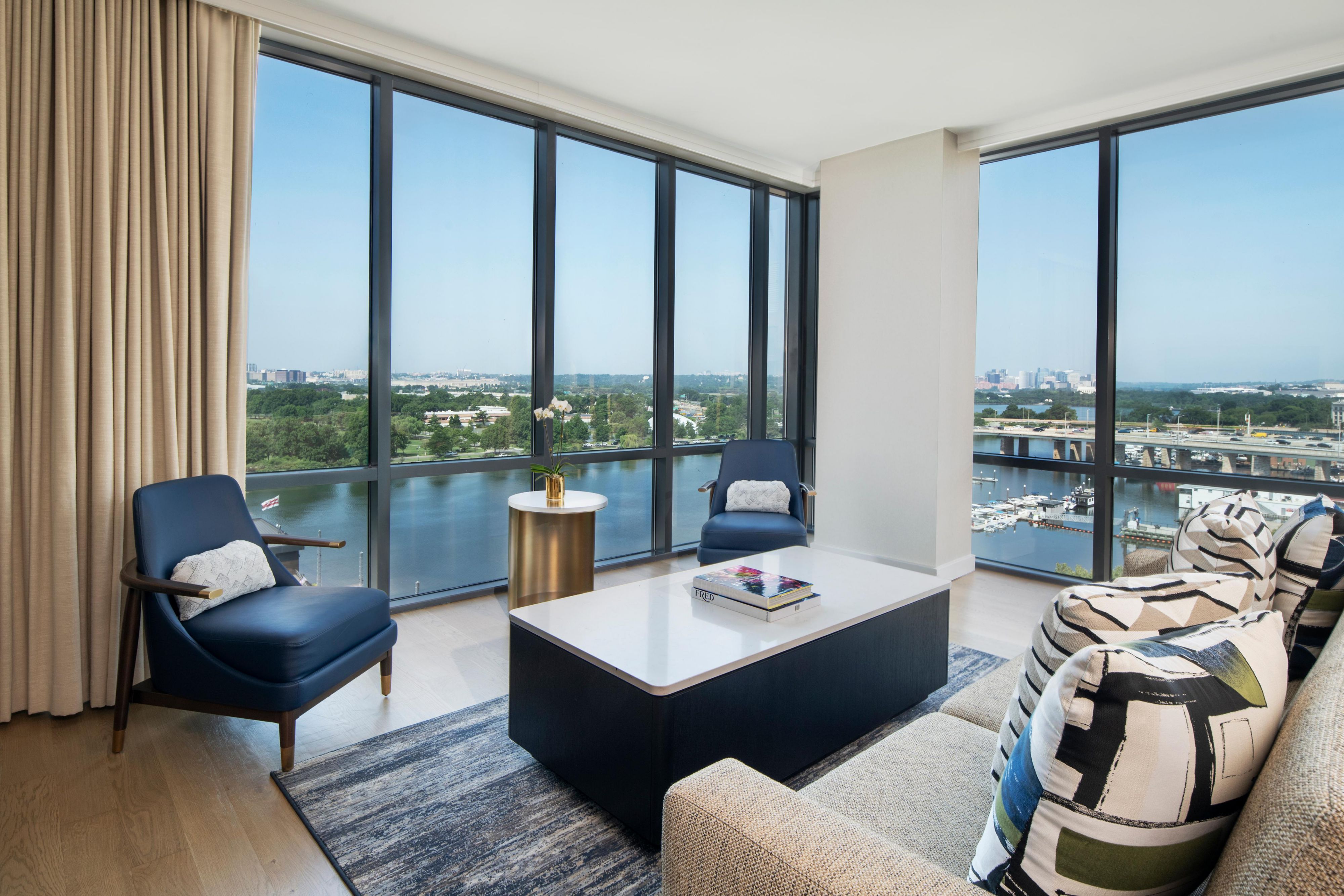 Suite living area with gold accents and sweeping river views.