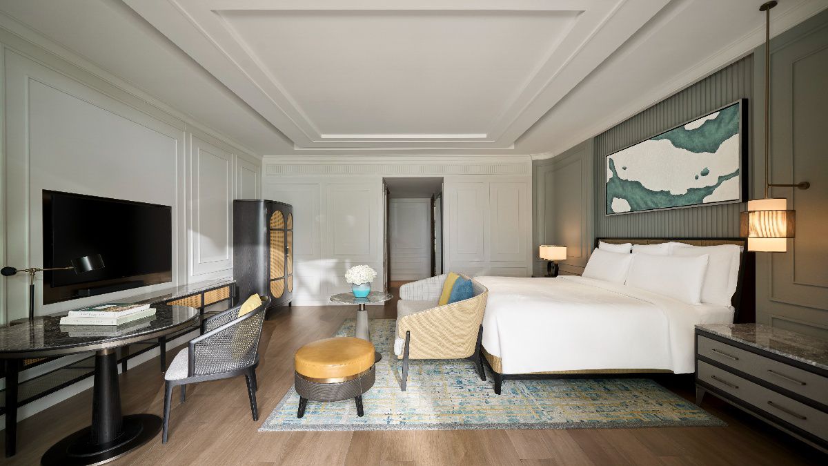 Luxury junior suite bedroom with modern furnishings and TV