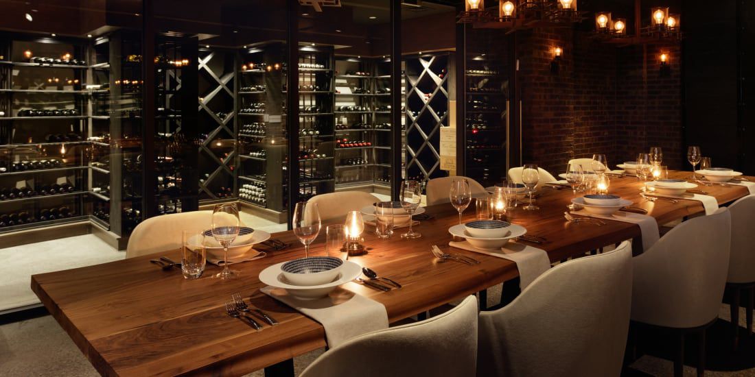 A dimly lit dining table in a wine cellar.