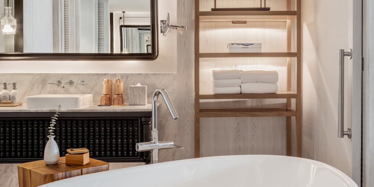 A well-appointed hotel bathroom with a soaking tub and carefully place amenities.
