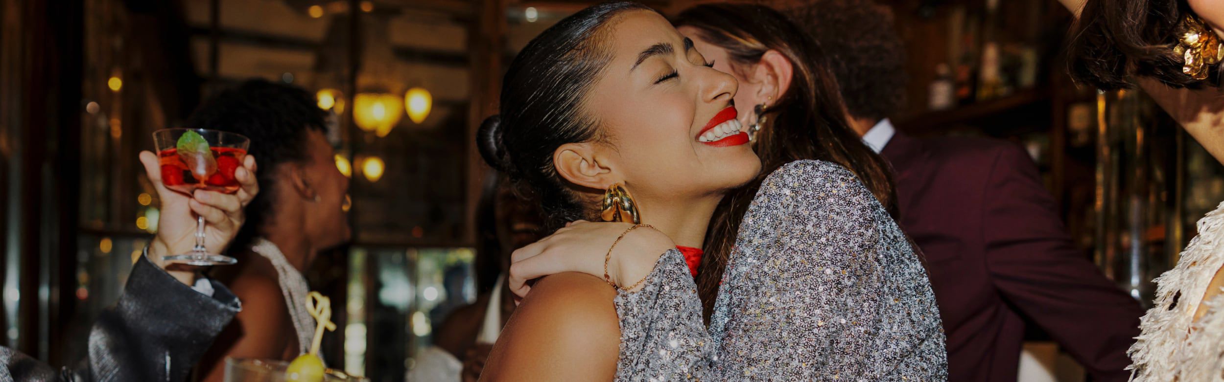 Two women hugging each other in greeting.