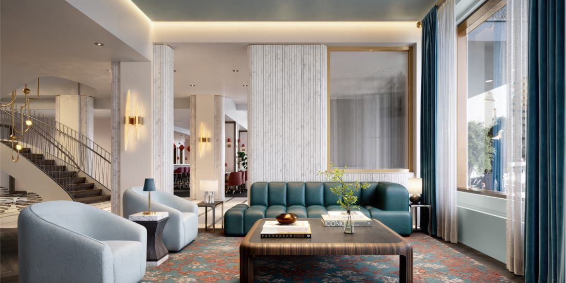 A chic lobby lounge with a sweeping staircase and modern seating.