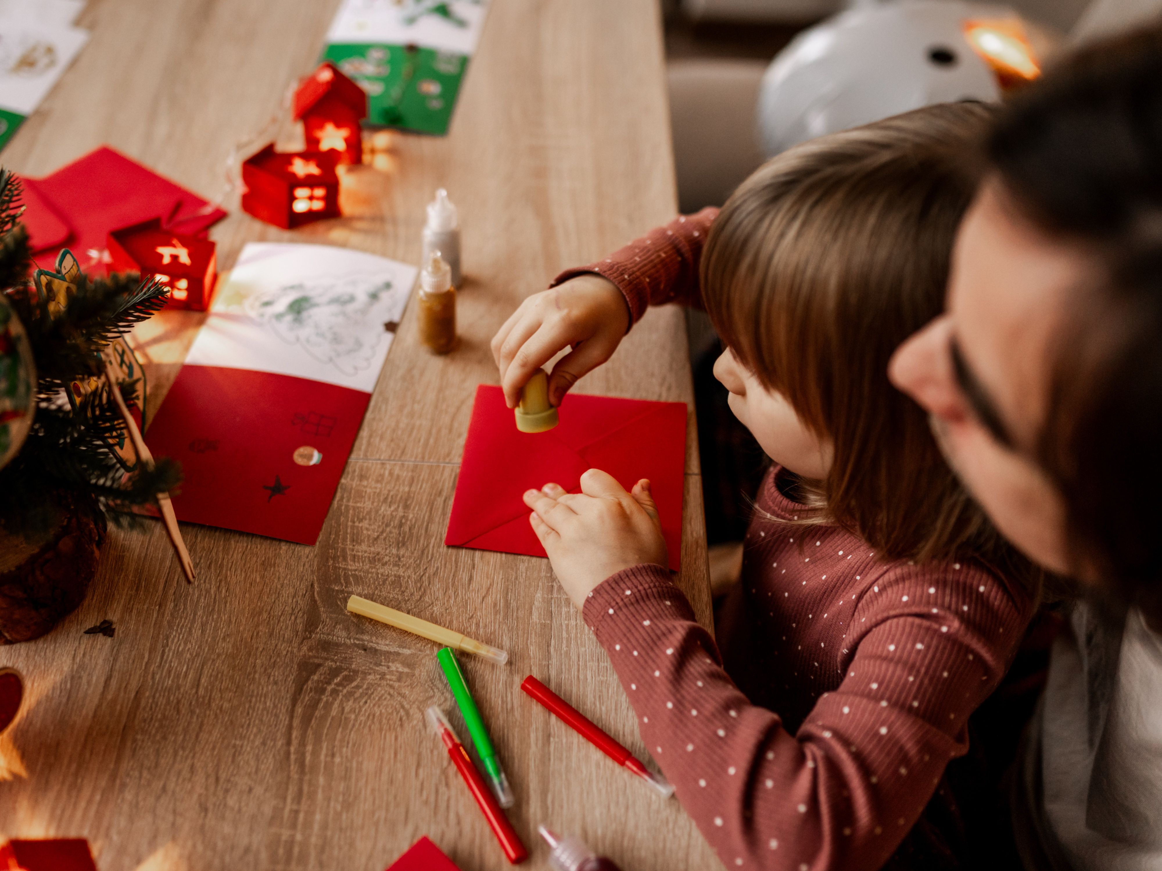 Kid making Christmas cards with a parent
