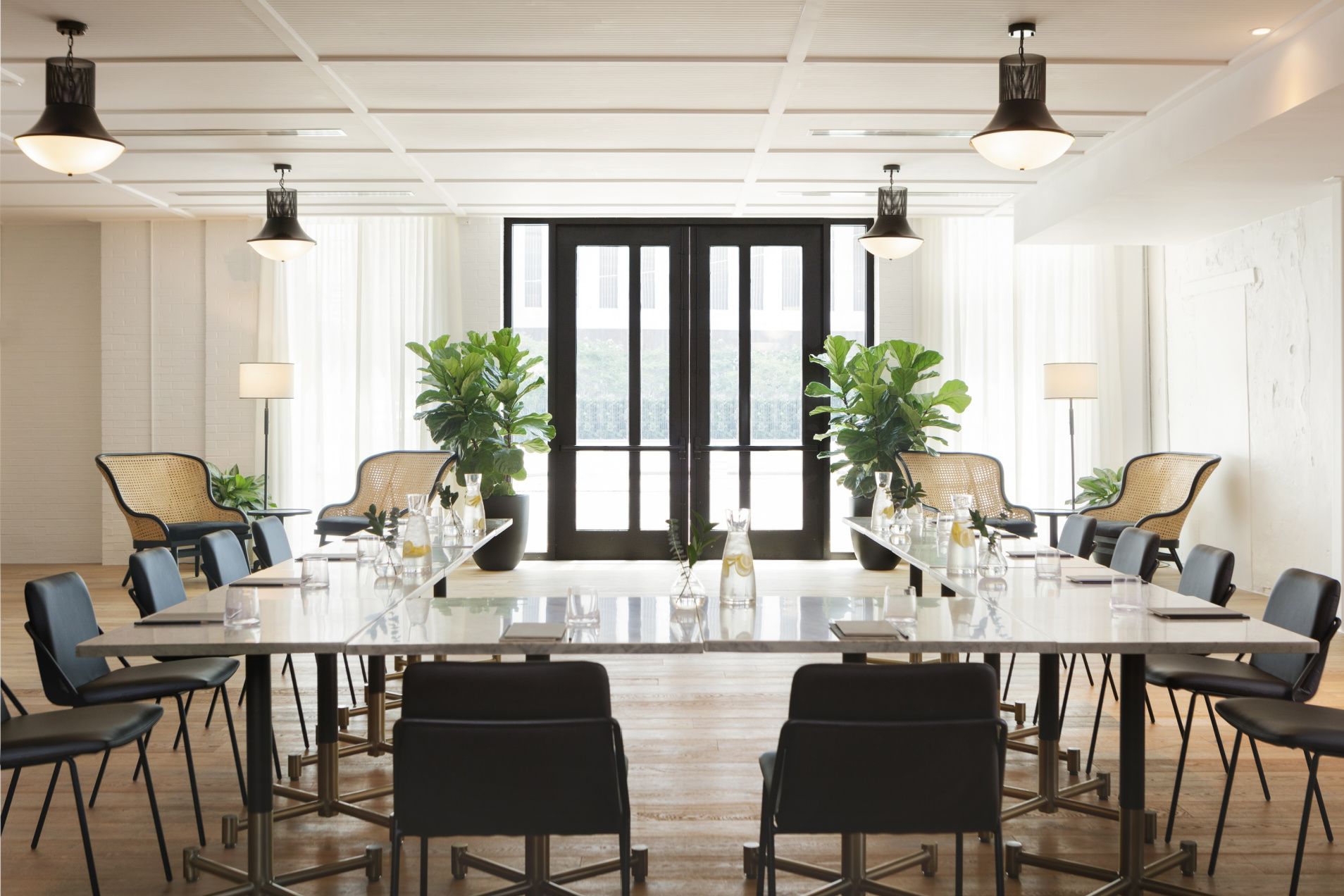 bright natural light in a spacious meeting room in a u-shape setting with plants