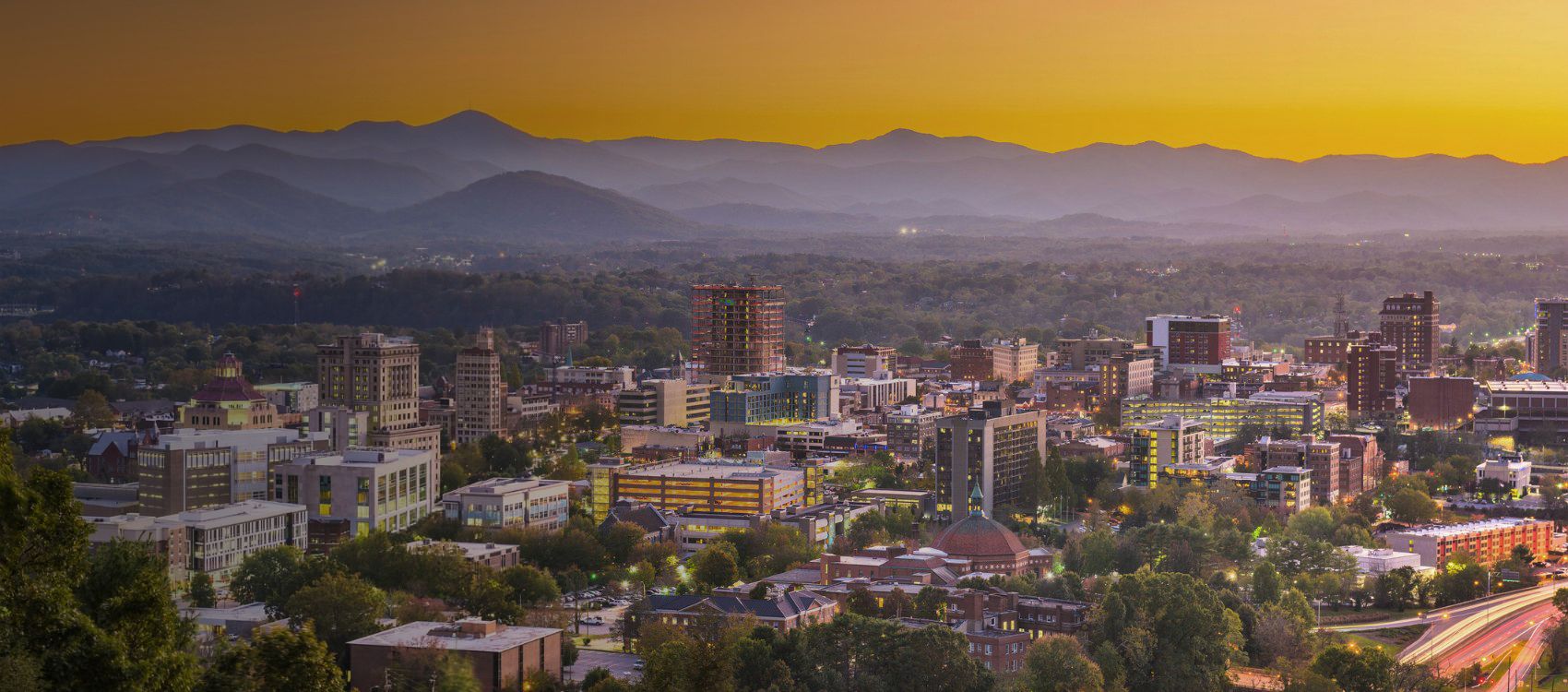 asheville north carolina city buildings in the foreground with blue ridge mountains in back