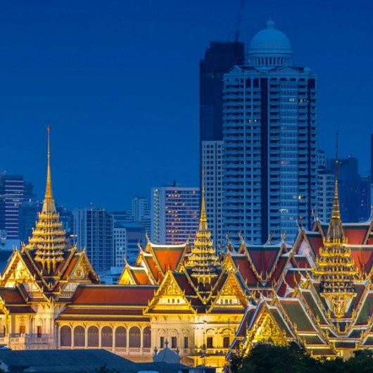 Kiến trúc cổ kính với ánh đèn vàng rực trên nền trời xanh thẳm với các tòa nhà chọc trời