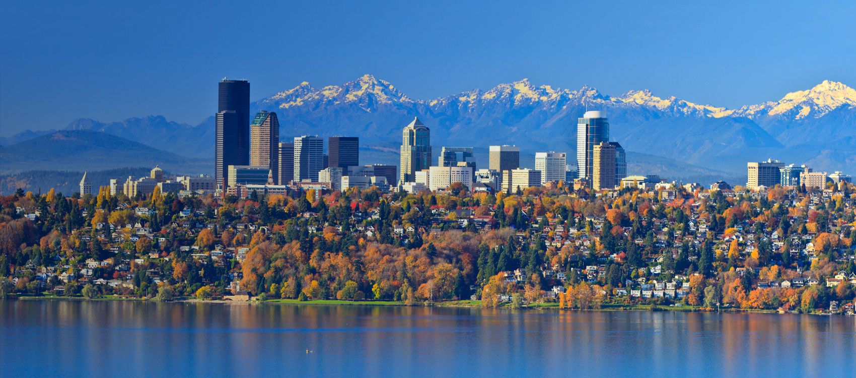 snow capped mountain range with city skyline in the foreground