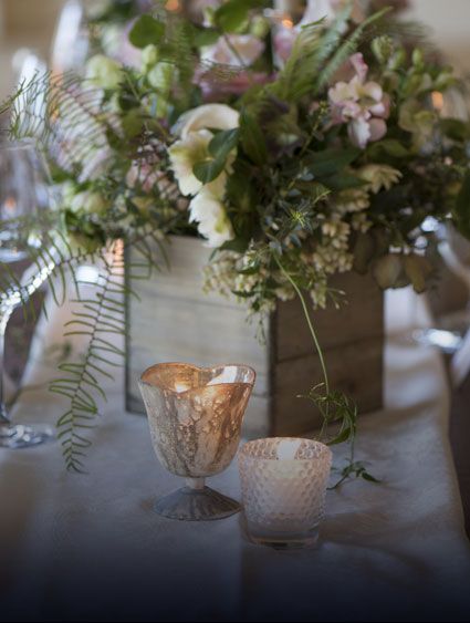 wedding centerpiece with light colored flowers in rustic wooden container