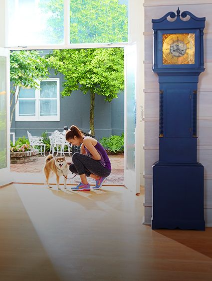 a woman in athletic clothes petting her leashed dog