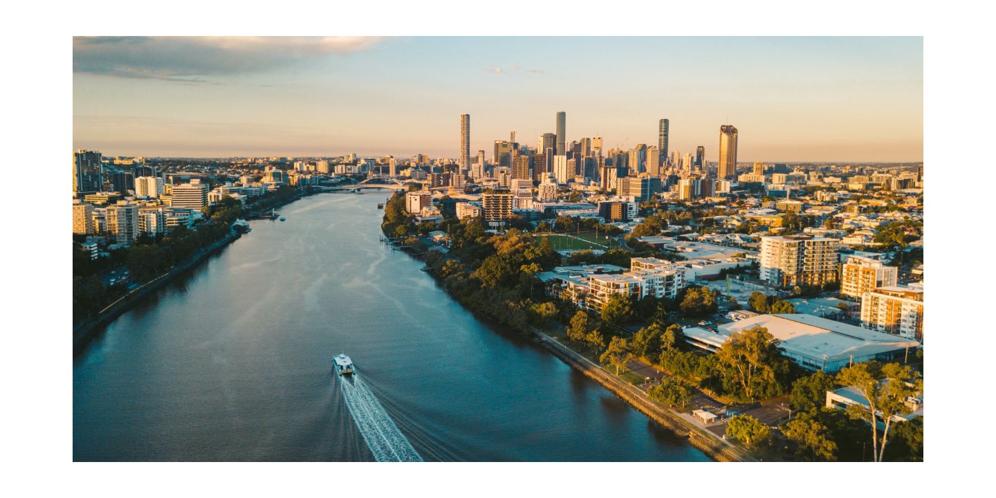 Aerial view of river entering city with downtown brisbane in distance