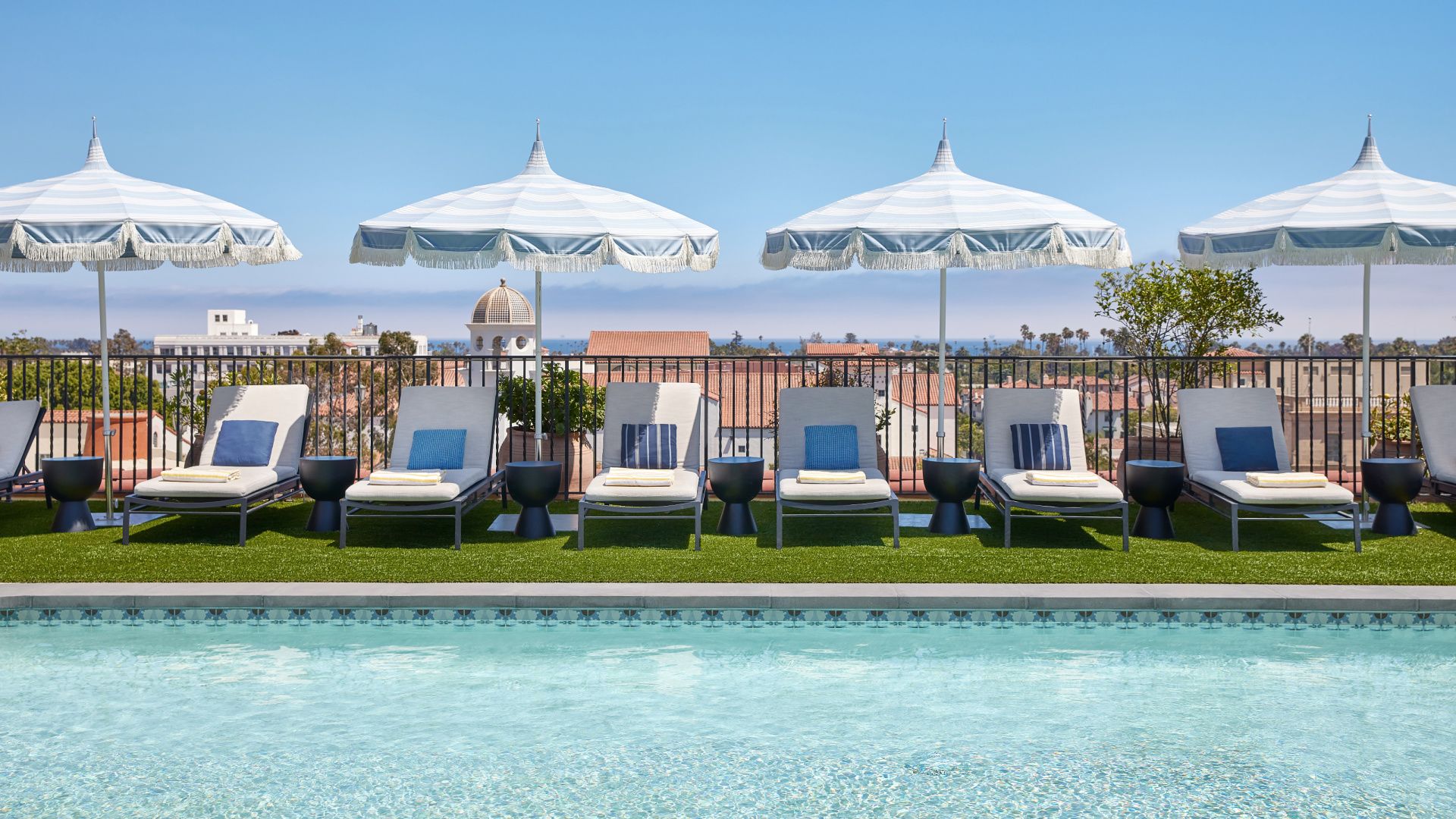 rooftop pool deck with chaise lounges and umbrellas