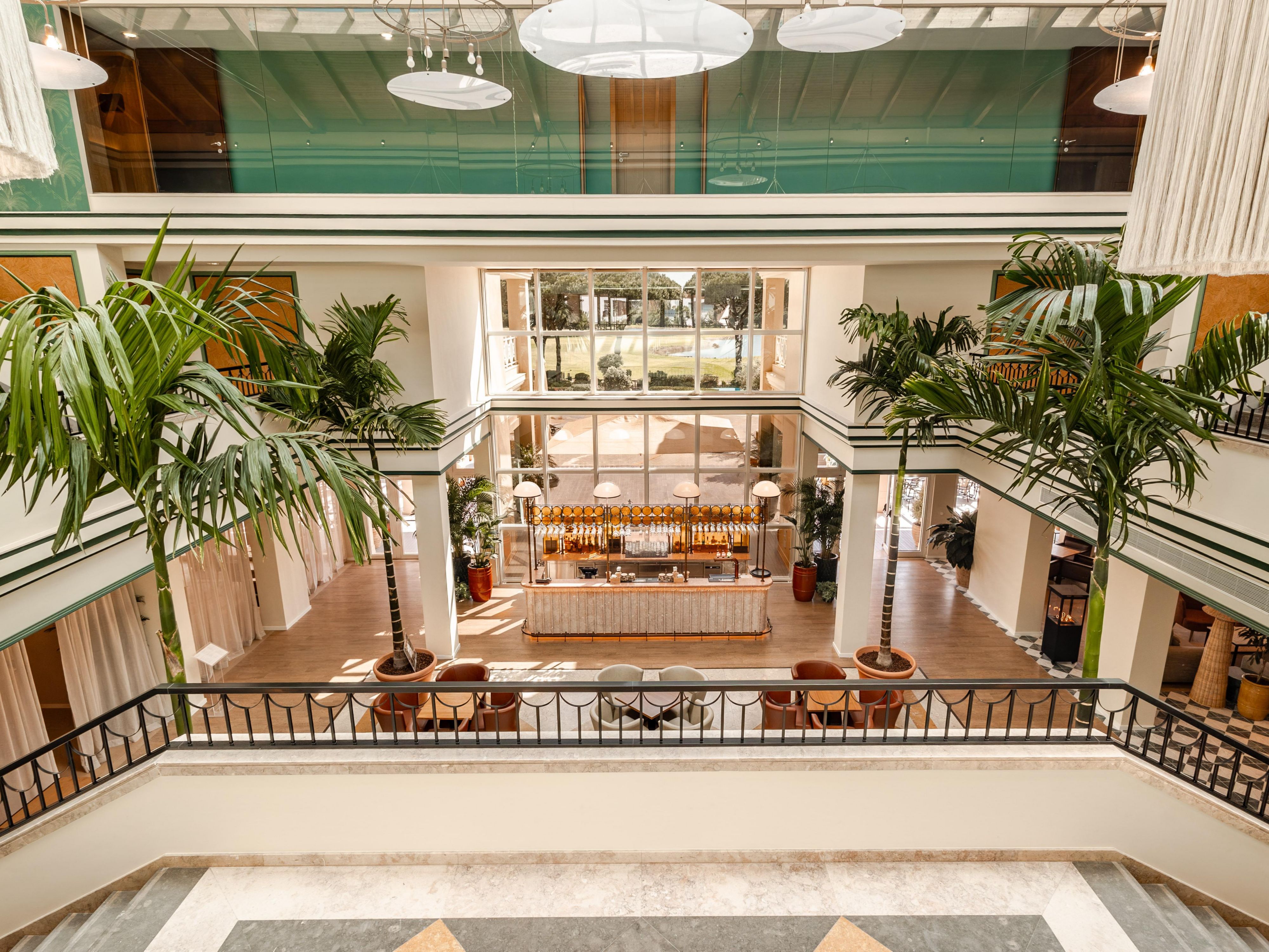 Luxury hotel lobby with grand staircase and garden decor