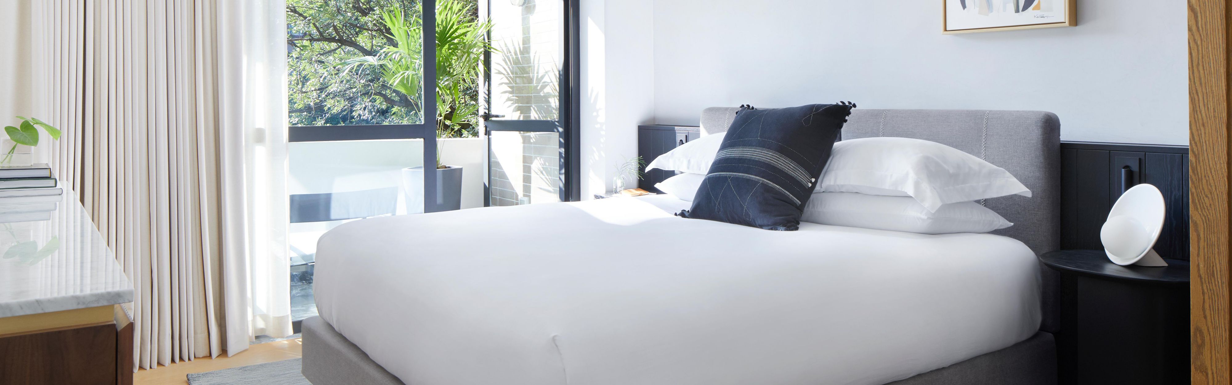 Serene guestroom in Polanco, Mexico City with bright natural light and crisp white bedding