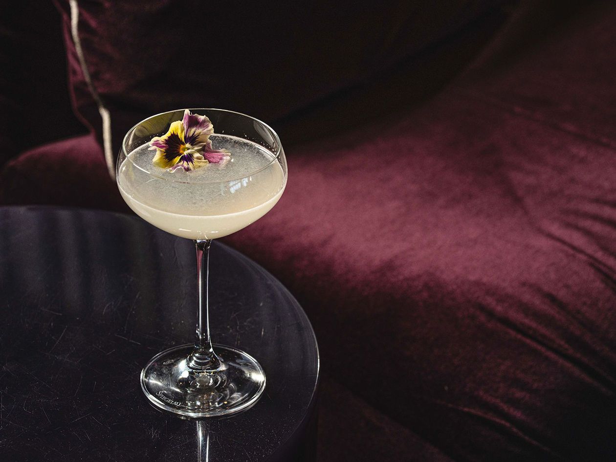 beautiful cocktail on sidetable by lush burgundy seating