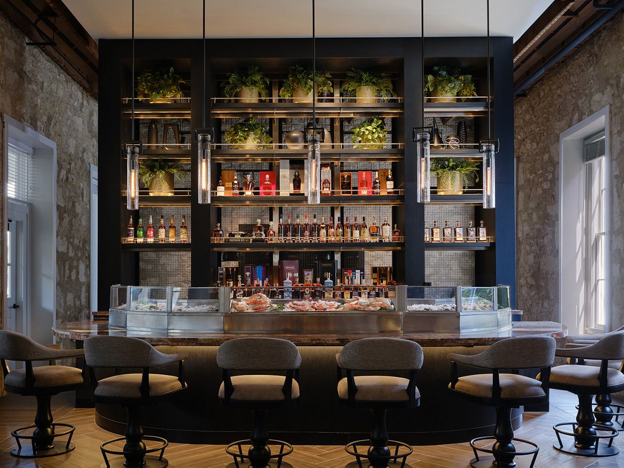 outdoor dining area on wooden deck surrounded by tropical trees and ocean views
