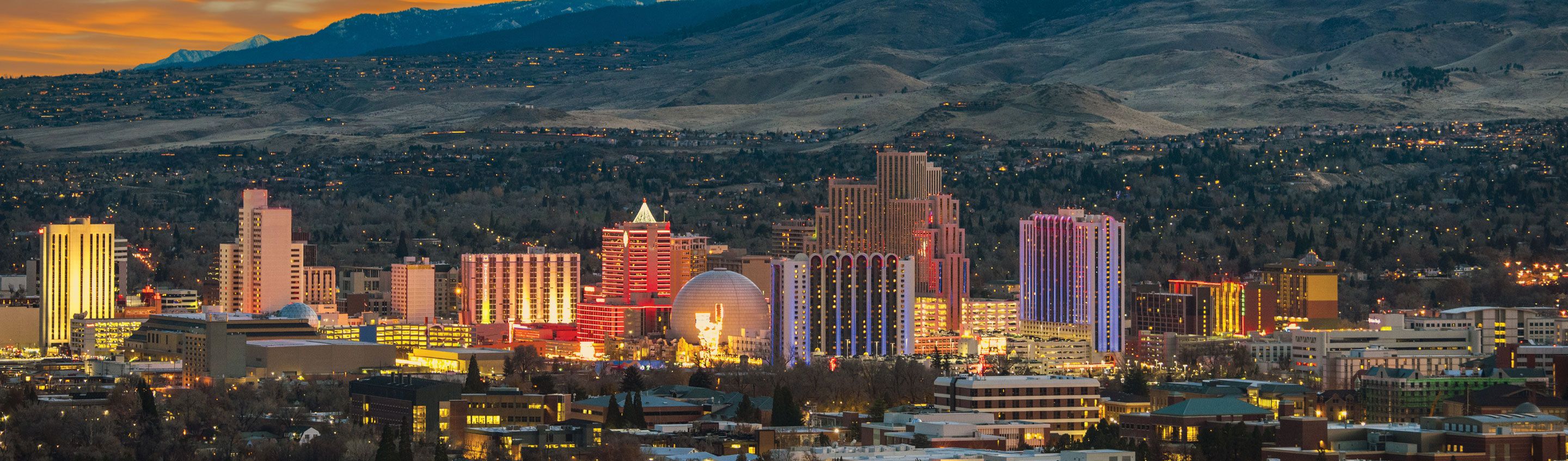 Sunset view of reno skyline with mountains beyond