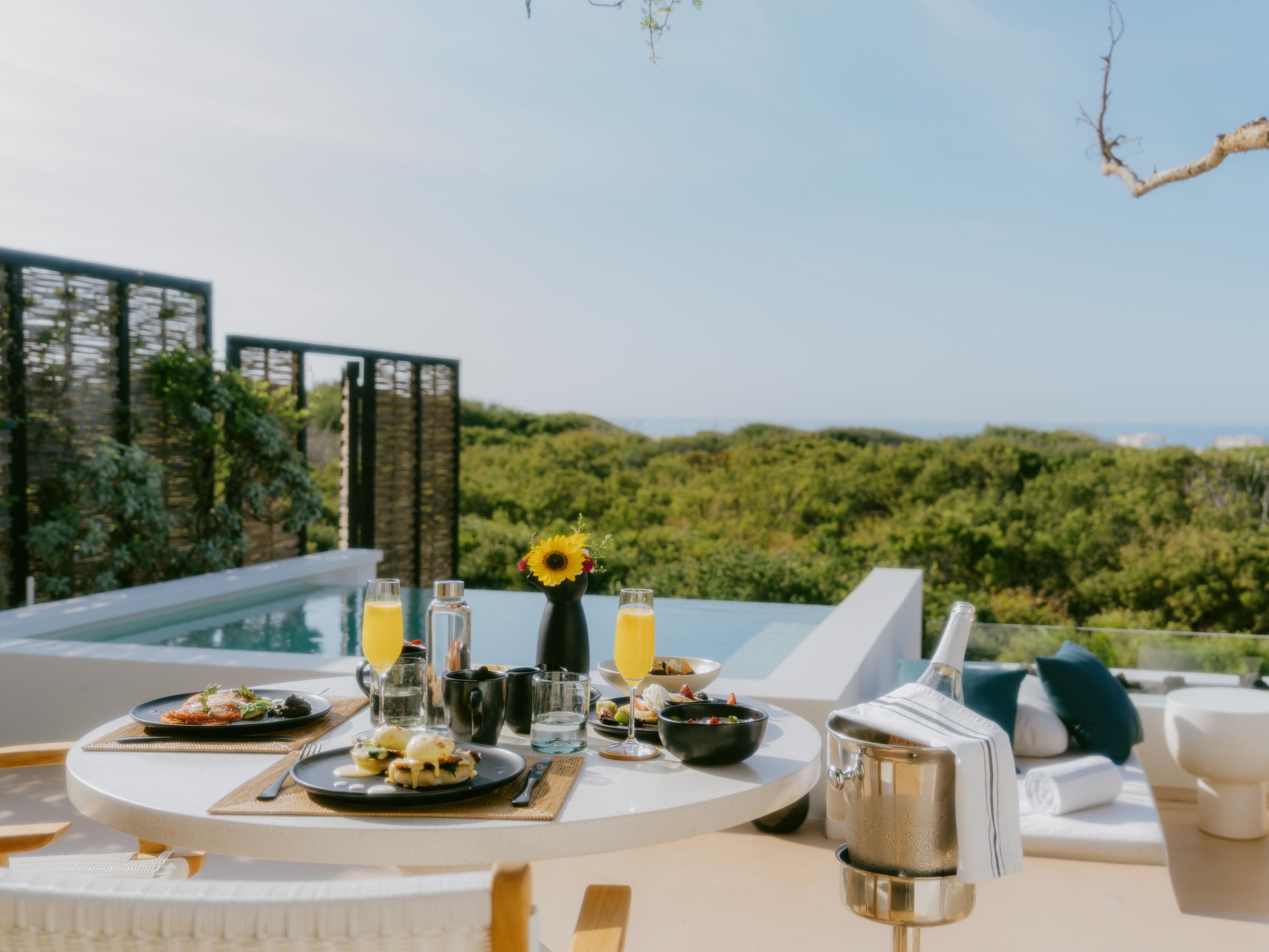 Meal set up in outside are of hotel room with ocean views.