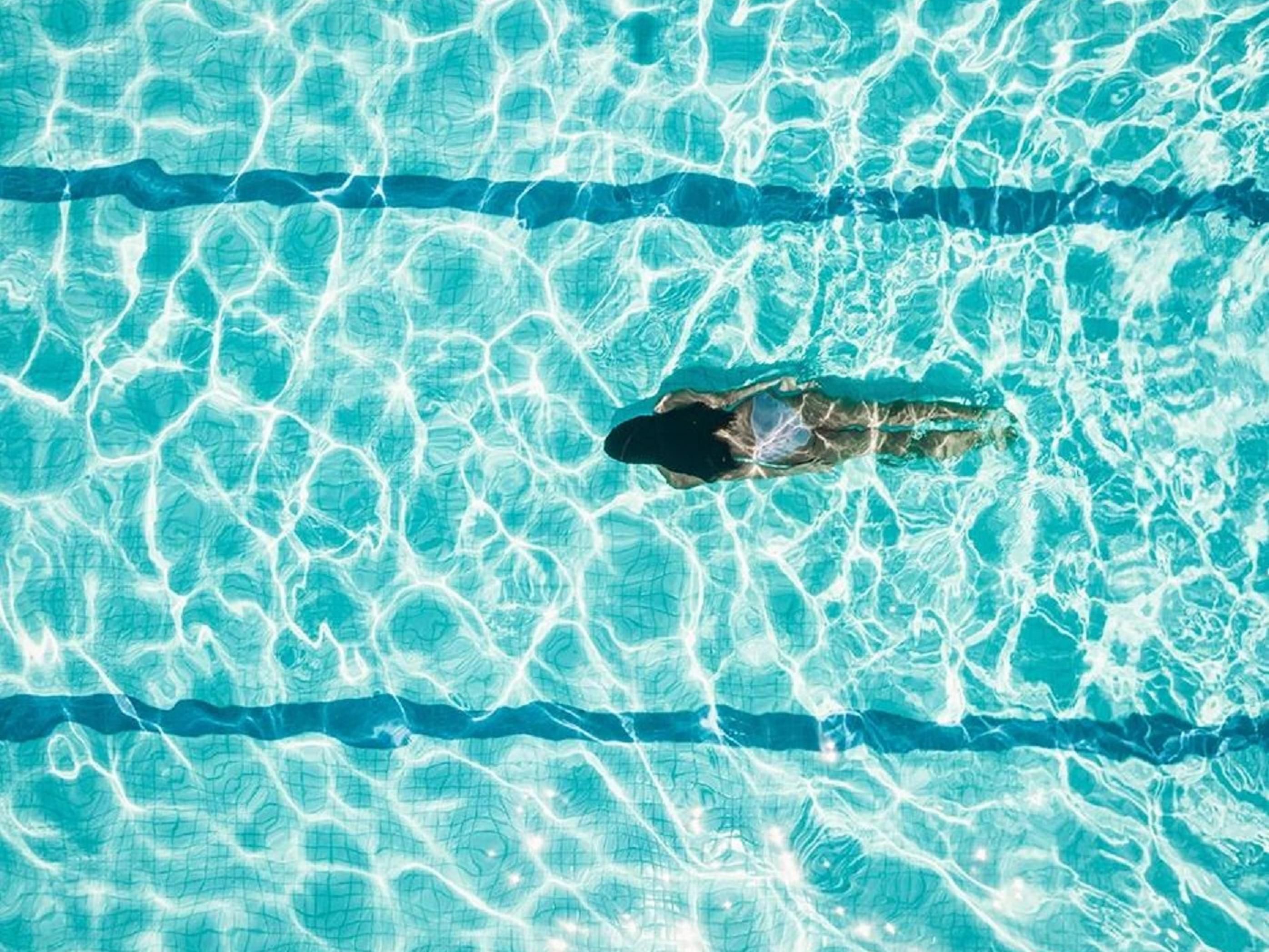 Woman swimming laps in pool.