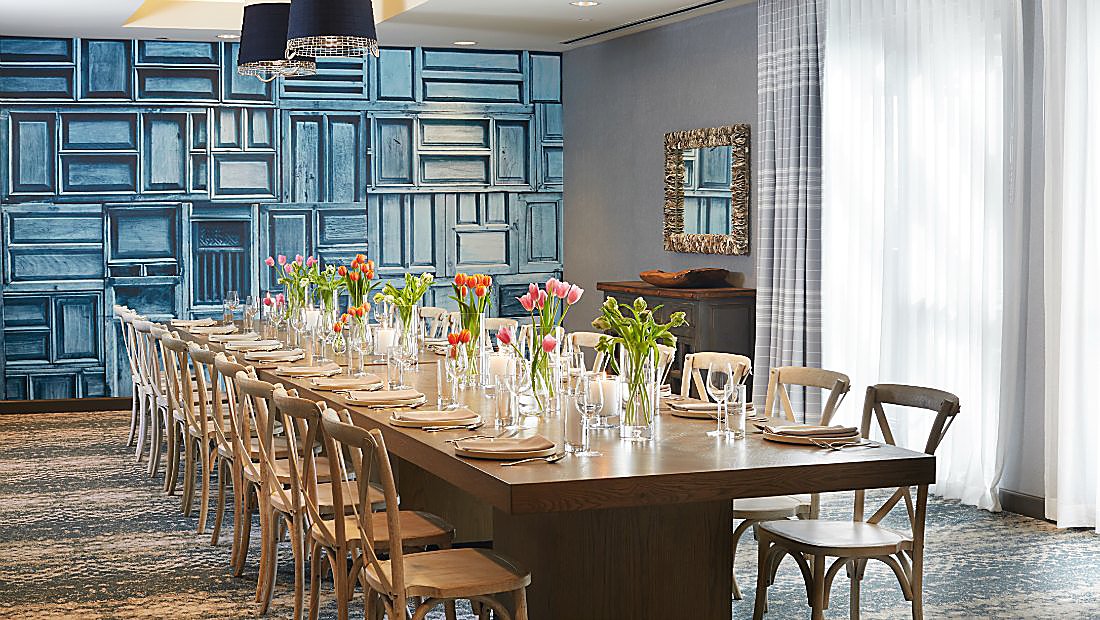 房间有长长的餐桌和墙壁，上面覆盖着蓝色的门