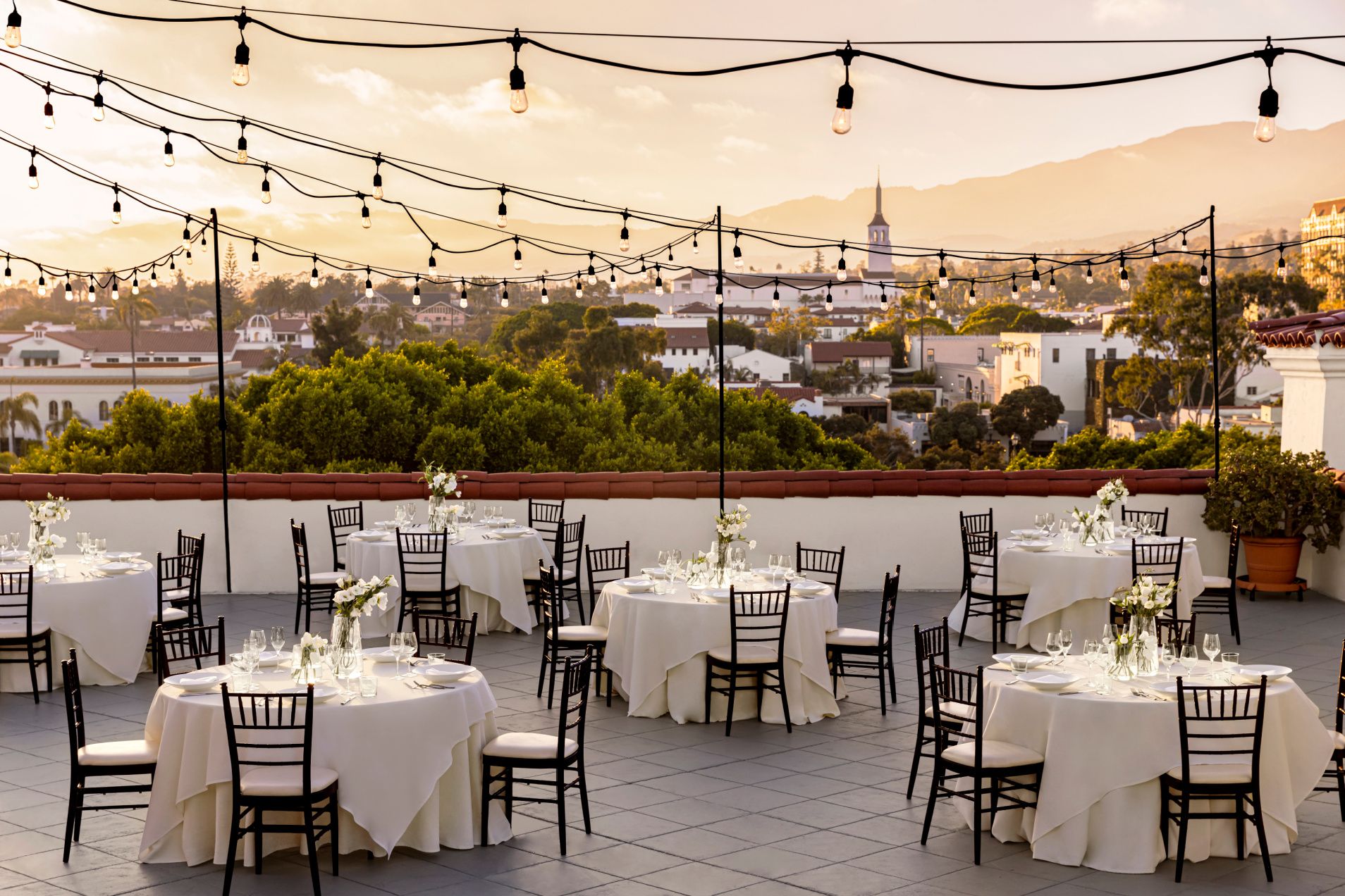 Roofttop deck overlooking santa barbara with formally set banquet tables