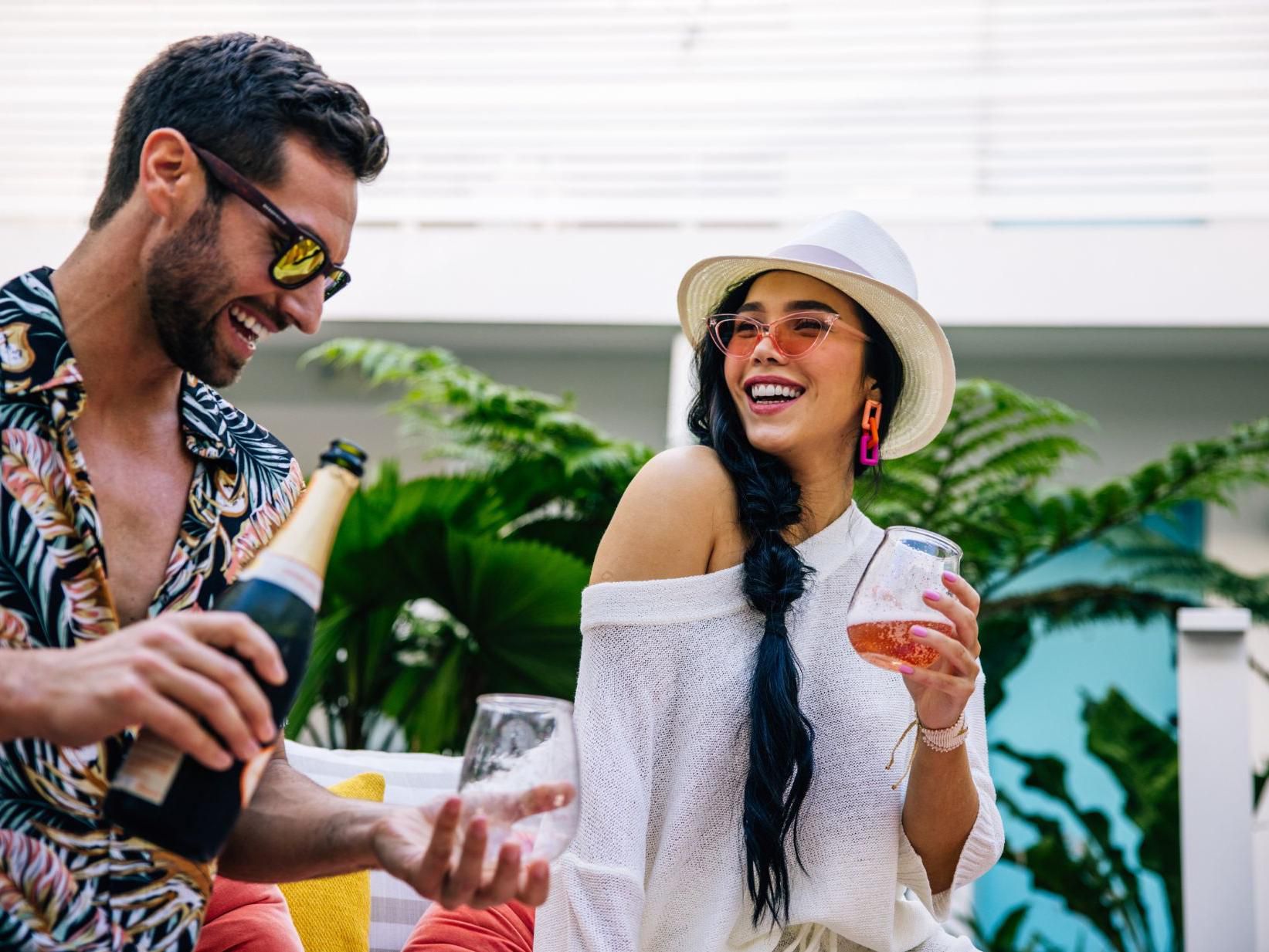 man and woman smiling drinking cocktails