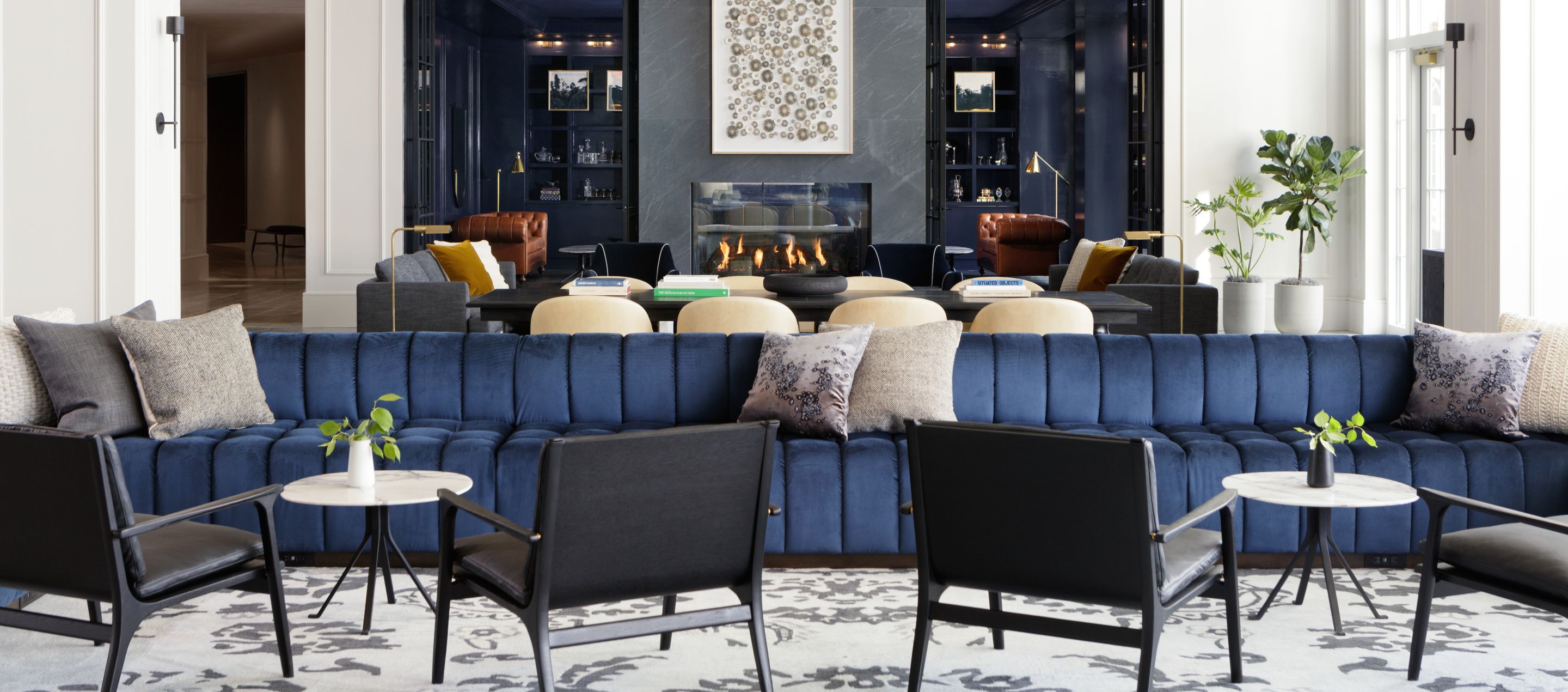 dramatic lobby living room with navy couches and central fireplace