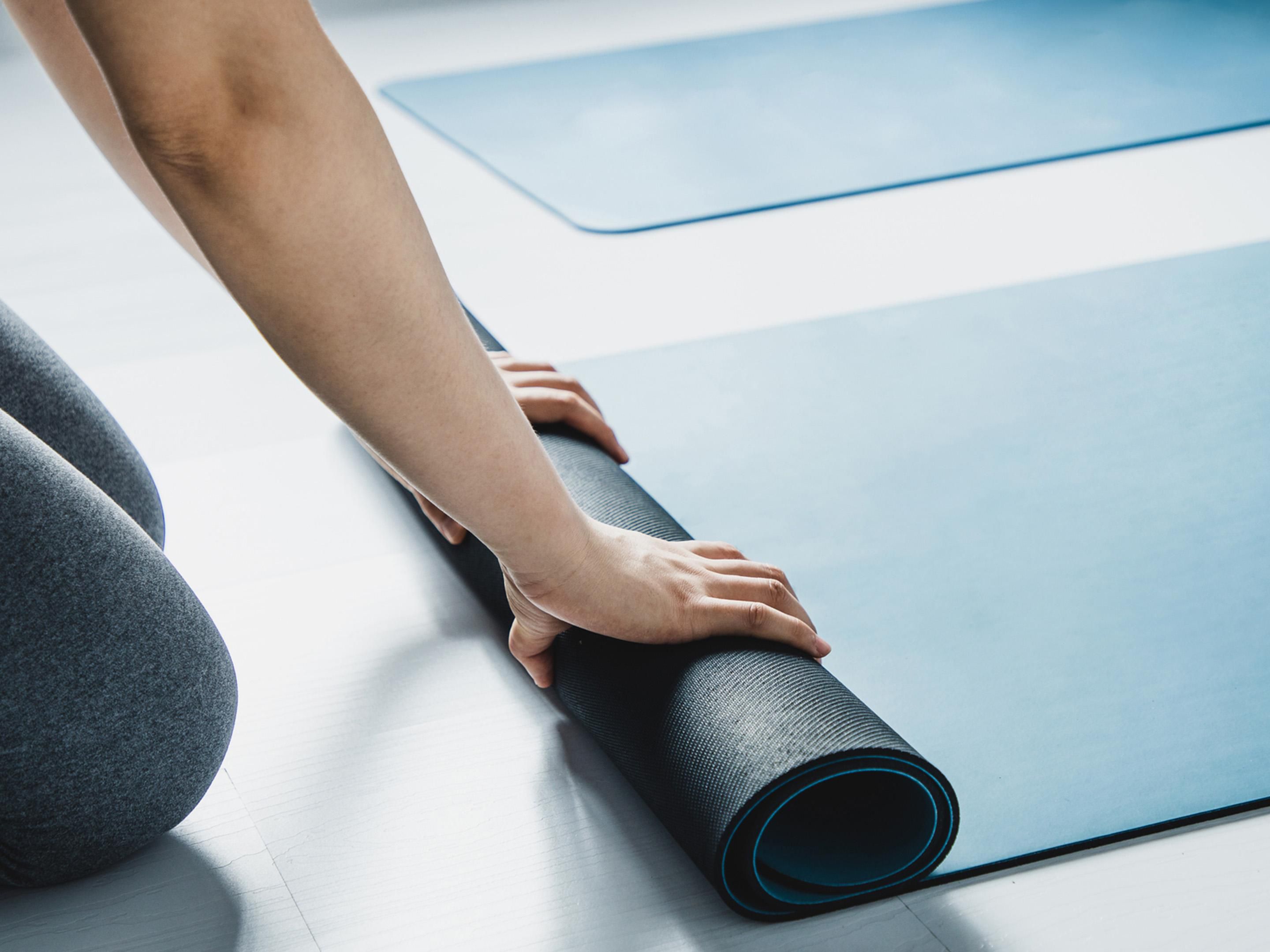 Rolling up a blue yoga mat