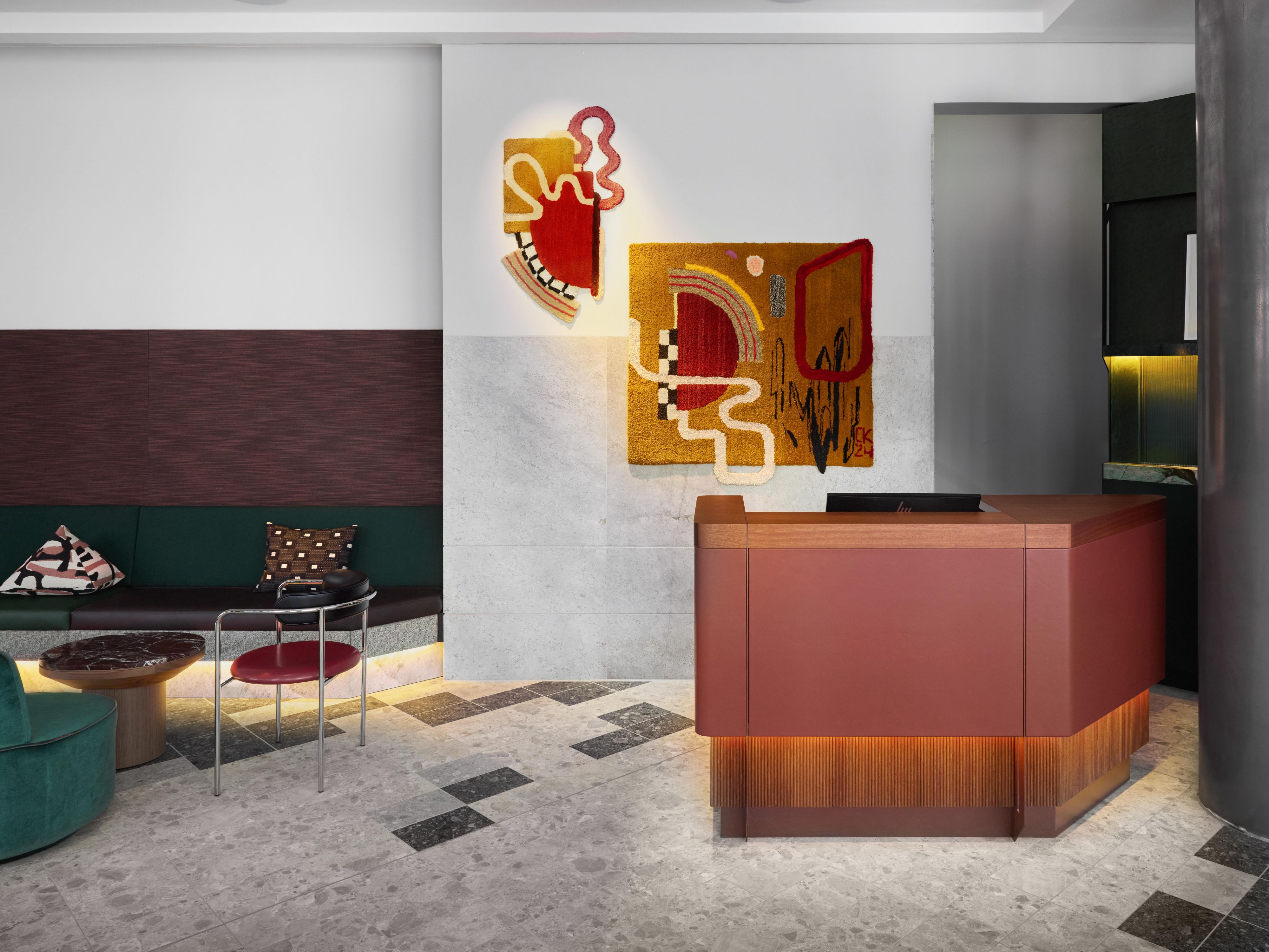 hotel receoption with colourful artwork, a green sofa, and a countertop