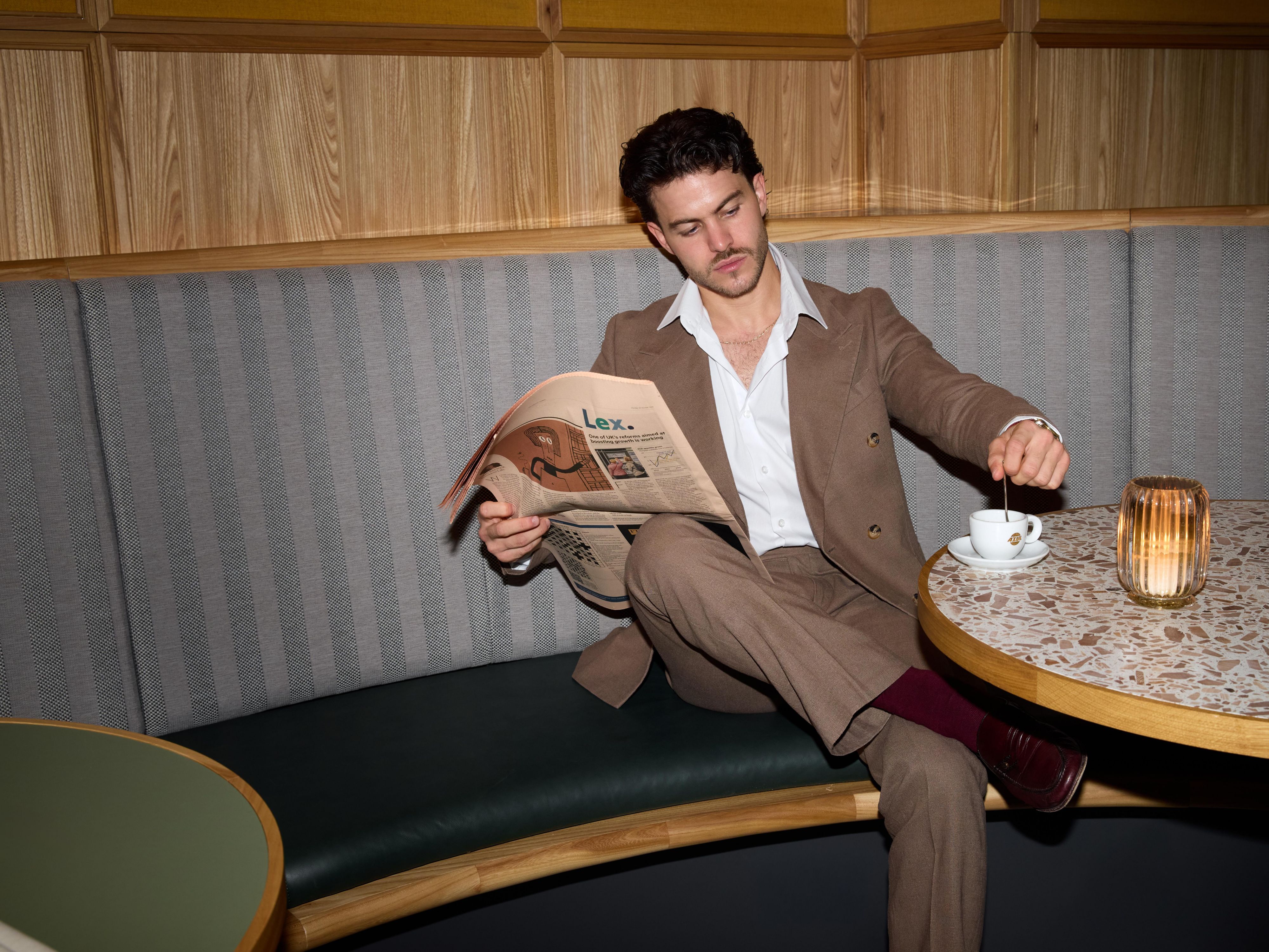Man enjoying coffee with a newspaper