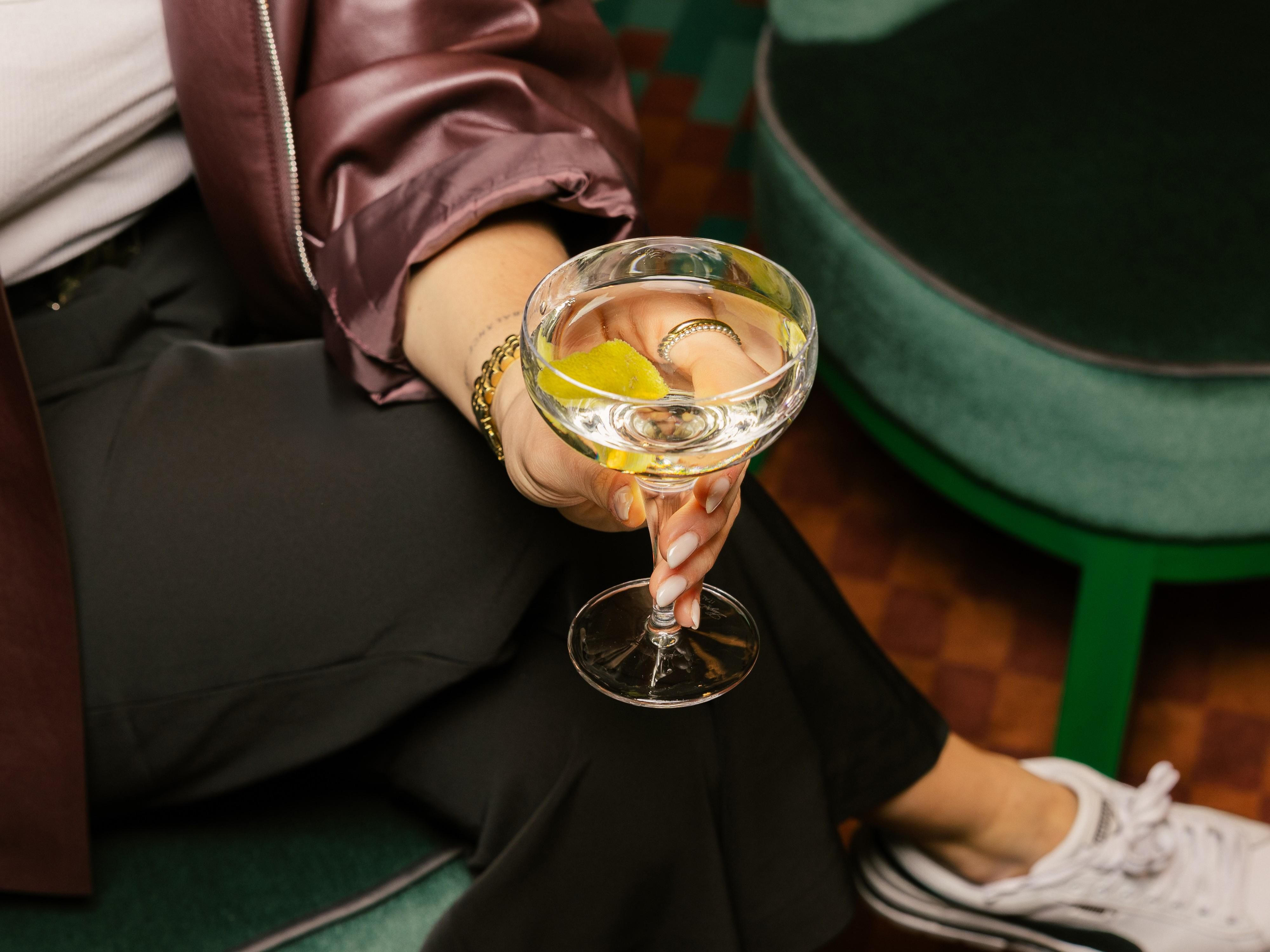 woman sitting and holding a martini cocktail