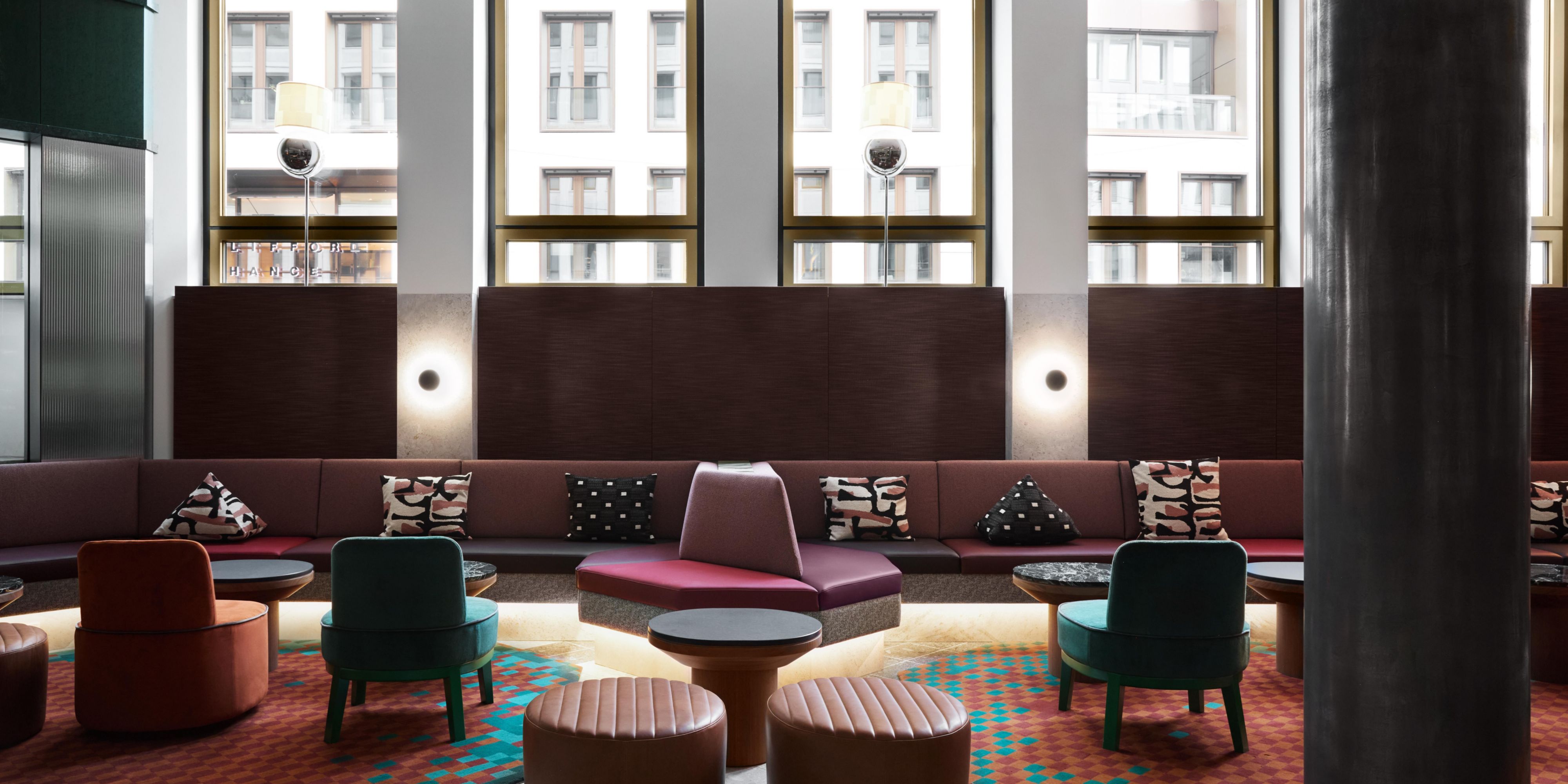 large seating area with cosy booths and large windows offering natural bright lighting