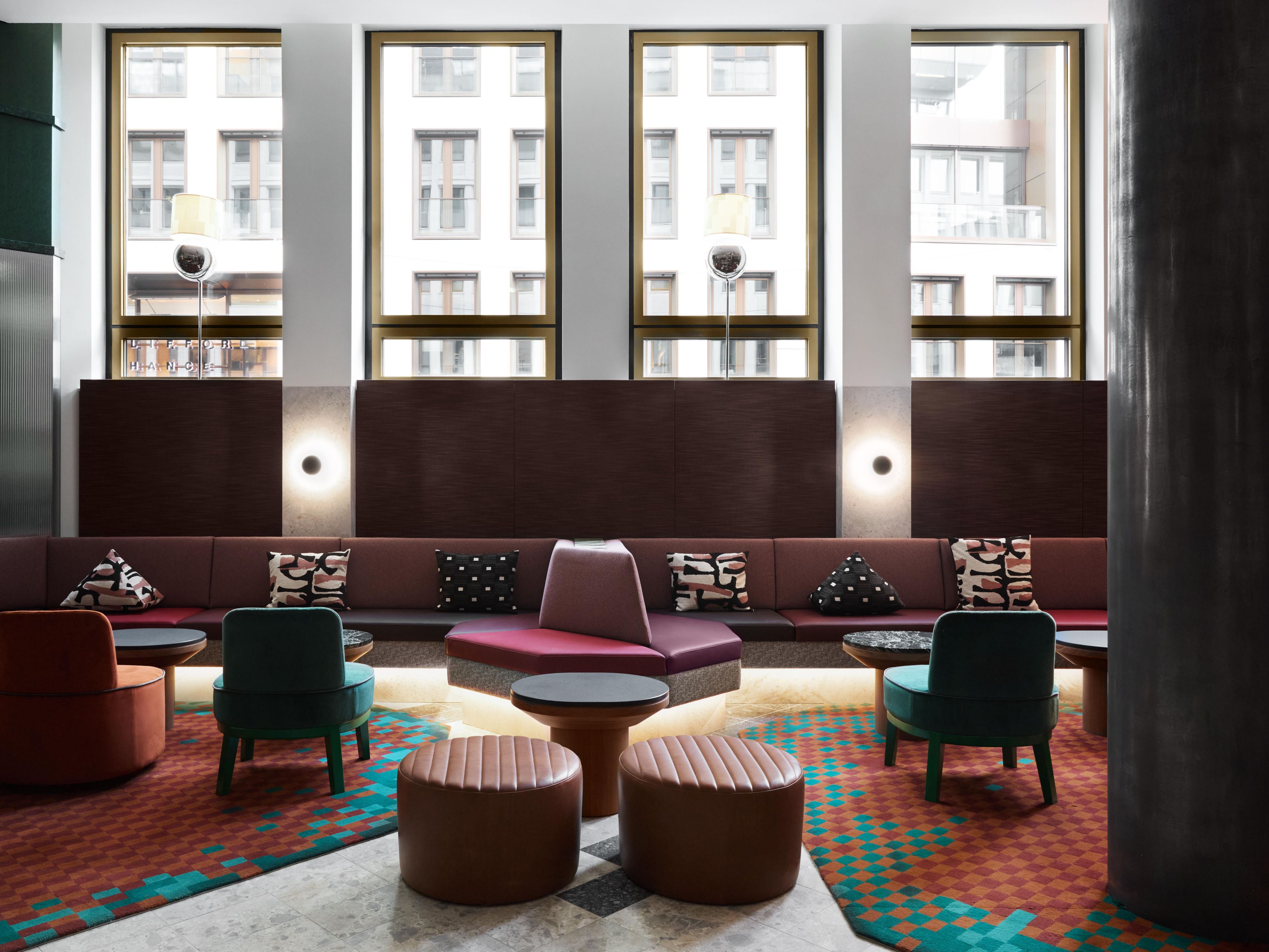 large seating area with cosy booths and large windows offering natural bright lighting