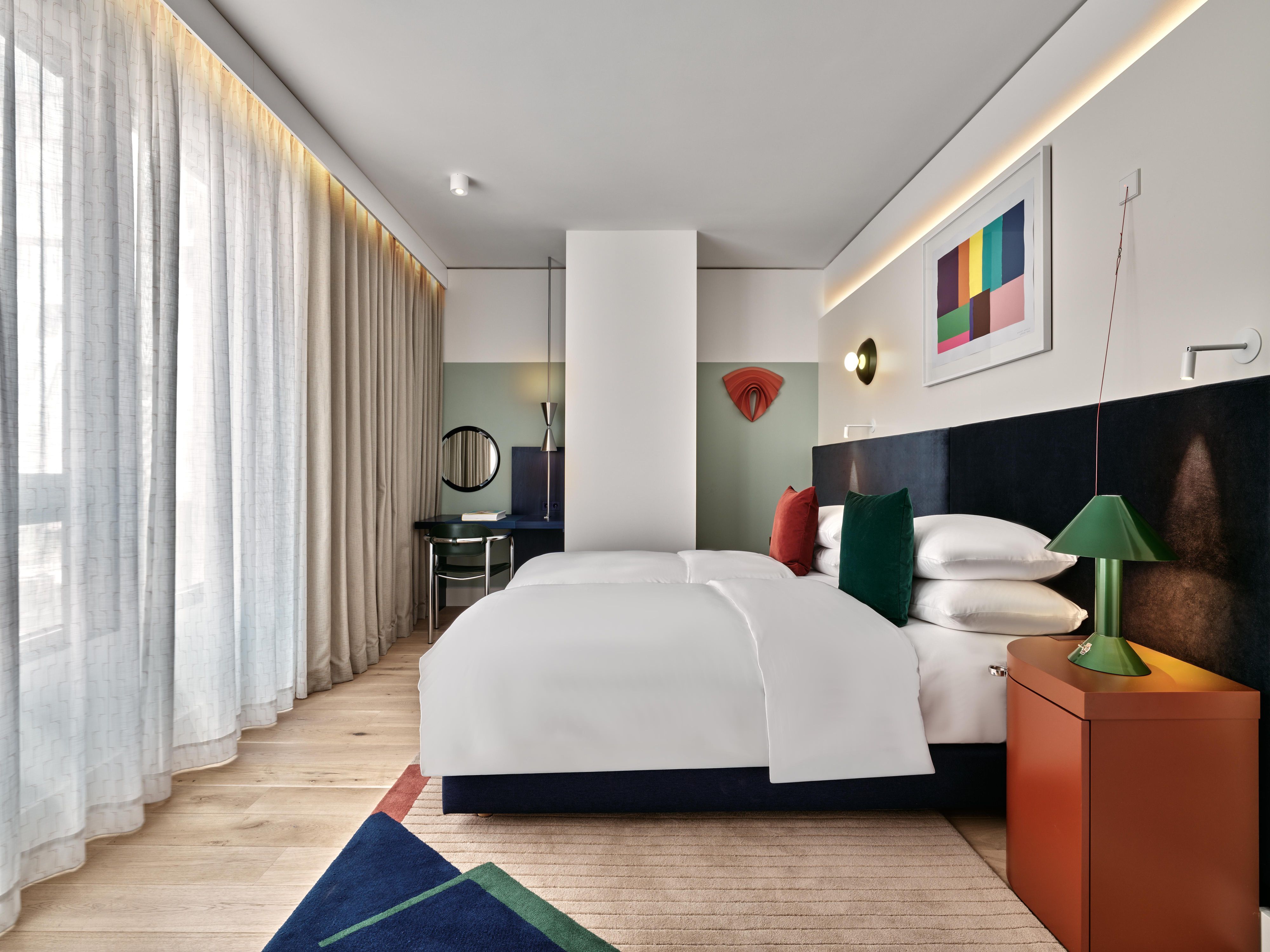 large room with two beds and a large window