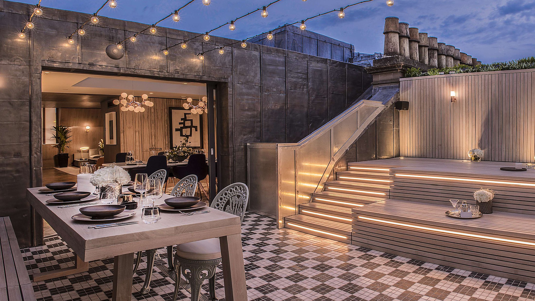 indoor/outdoor dining in a sunken restaurant patio with strings of cafe lights