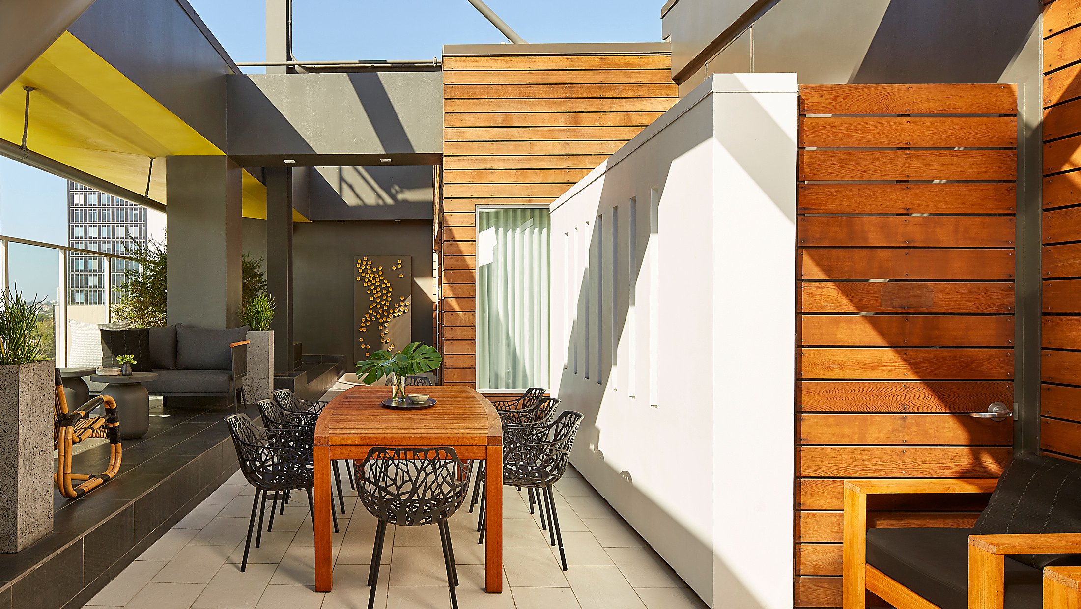 shaded table with seating for 8 on a hotel balcony overlooking the city