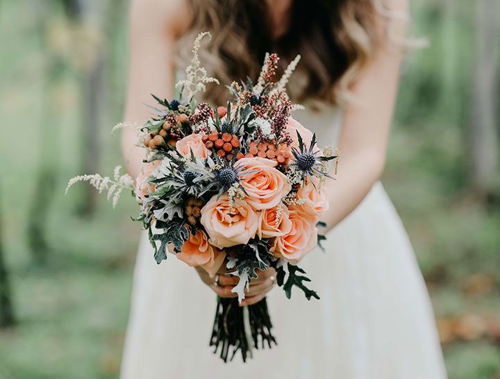 bride holding a bouquet of flowers in fall colors