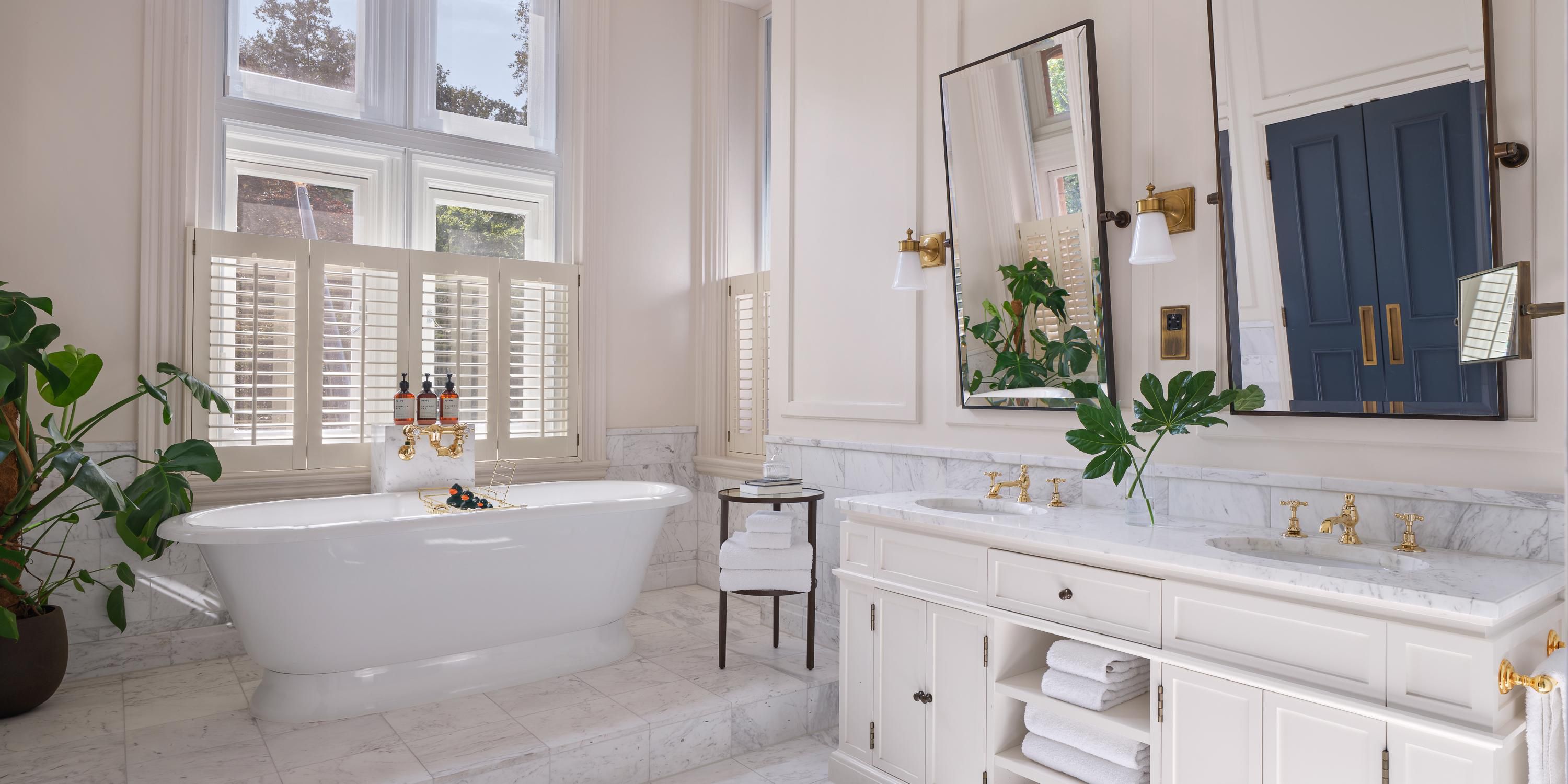 The marble bathroom features a waterfall shower and roll top bath.