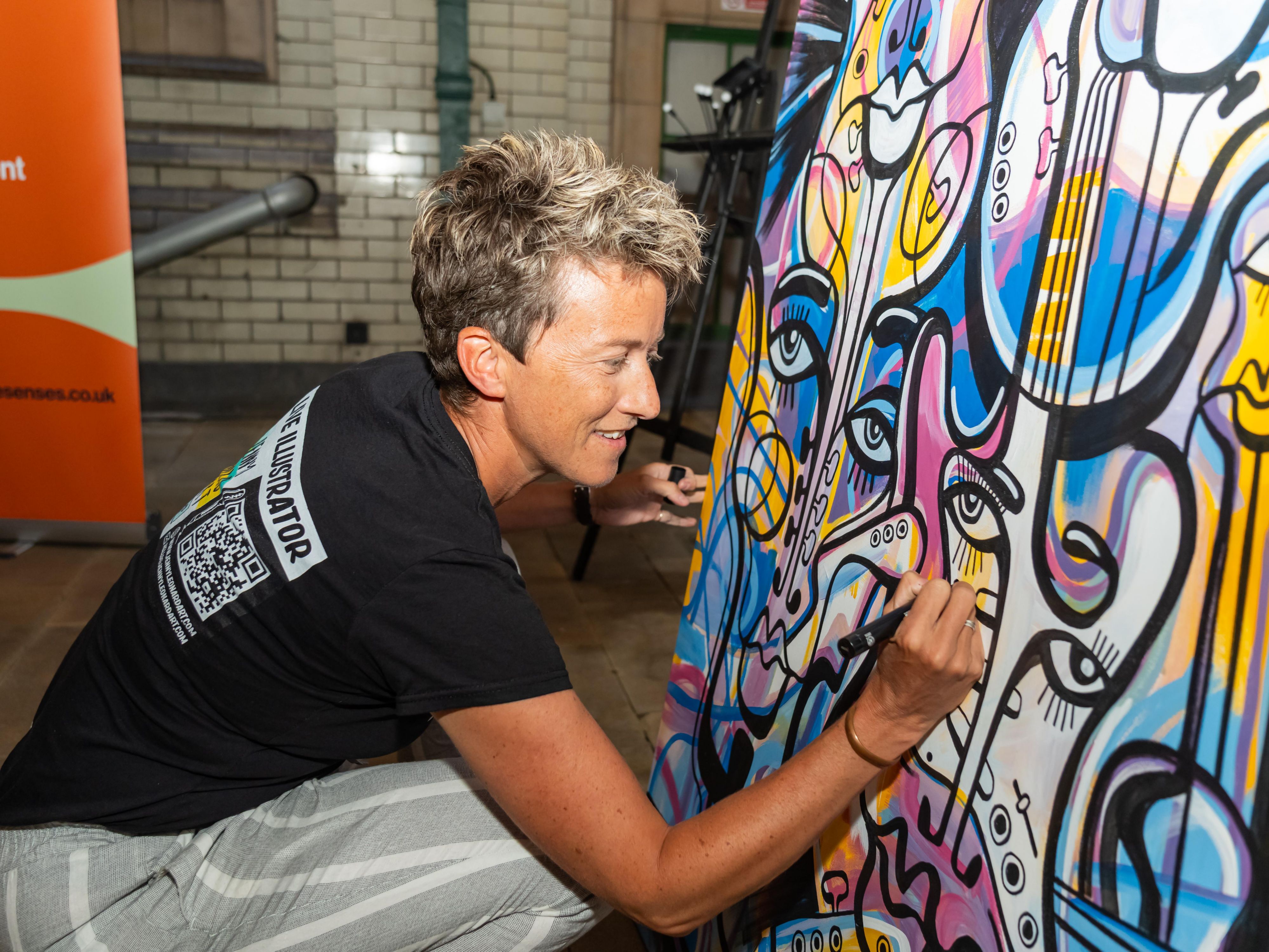 Female artist paining on her colourful artwork