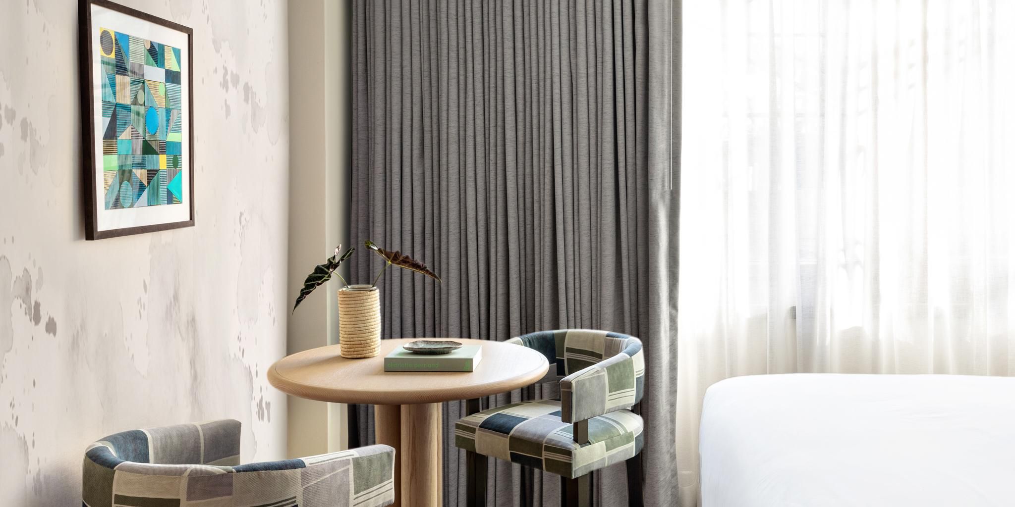 Chic double queen suite with small modern table and chairs