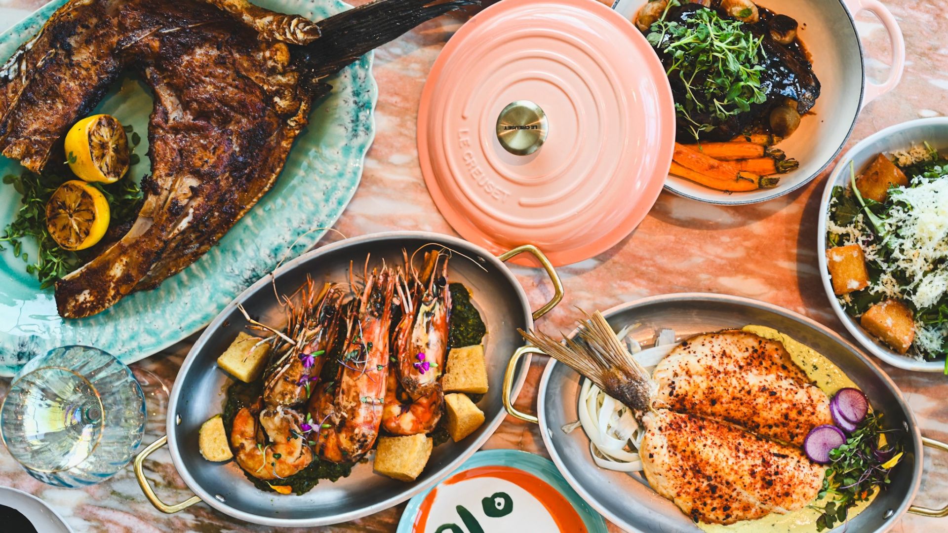 Table with 5 dishes of colorful gourmet entrees