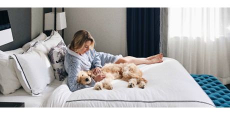 A woman and her dog cuddling on the bed