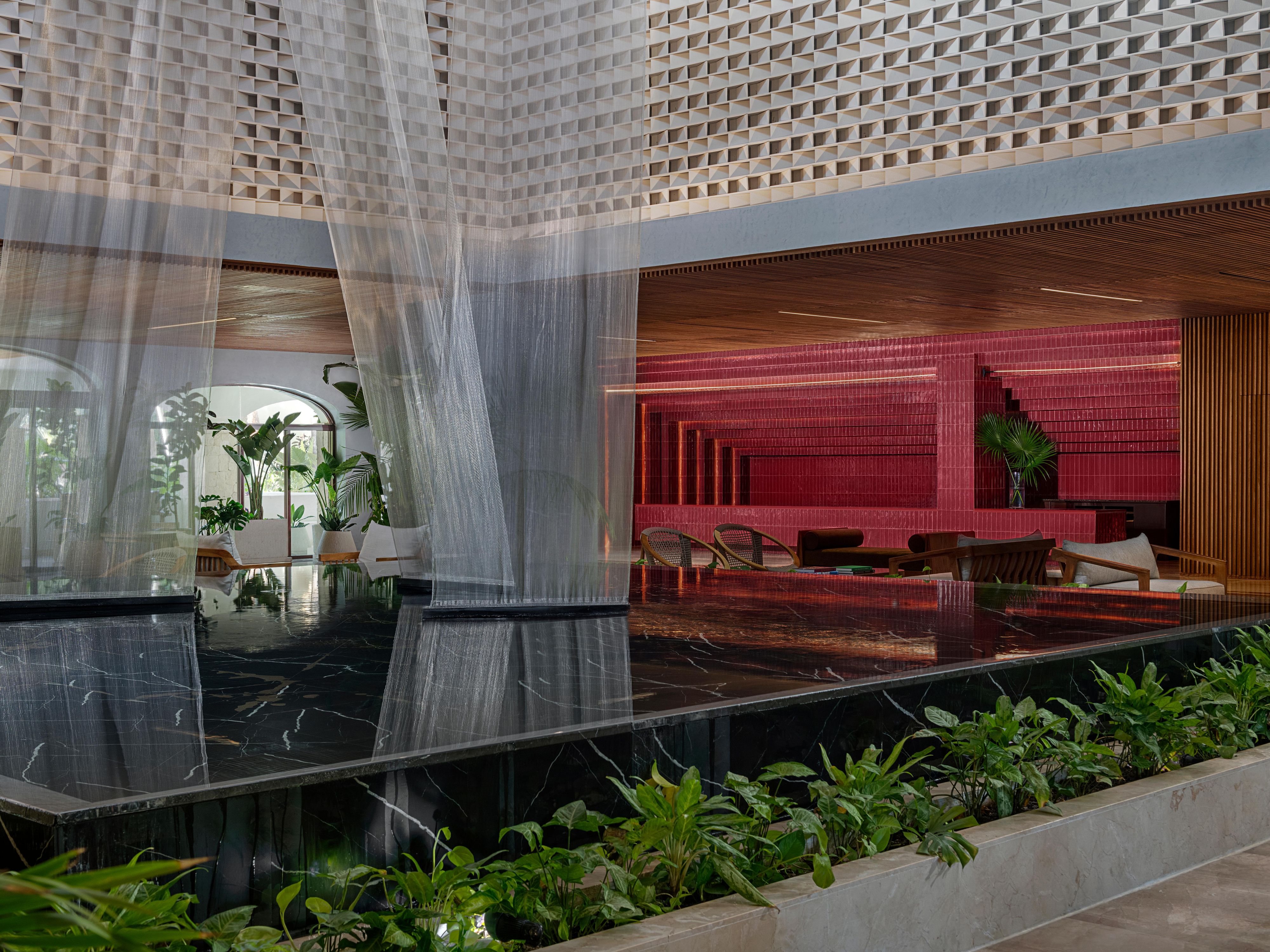 Hotel lobby with sculptural ceiling and illuminated bar