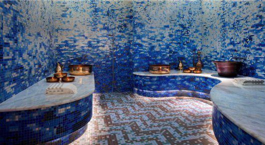blue mosaic tiles adorn the walls and ceiling in this spa