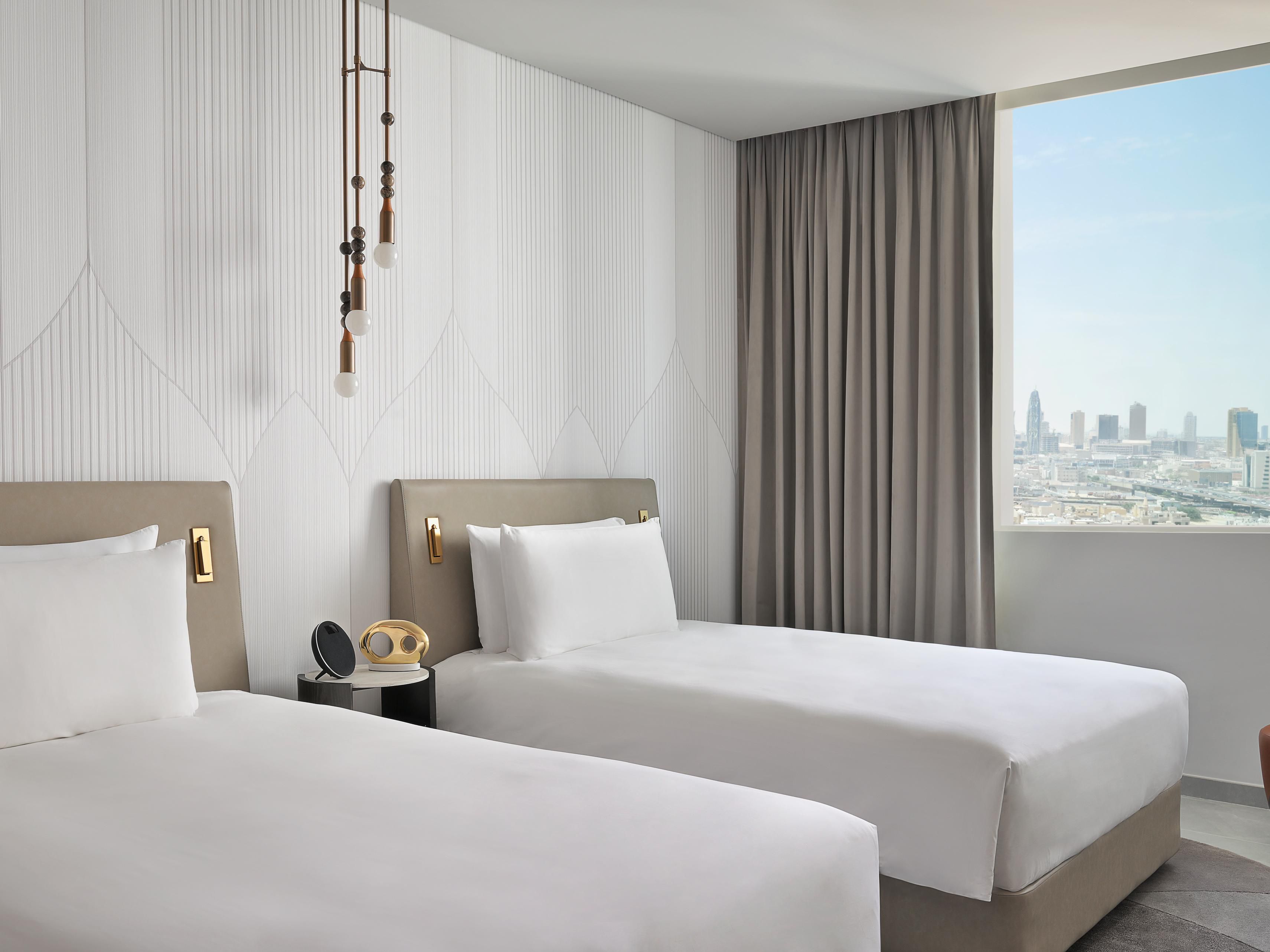 Twin room panoramic city views, sleek interiors, natural light