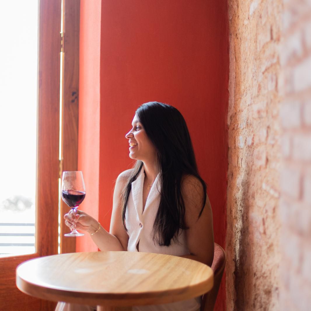 Woman by the window enjoying a glass of wine