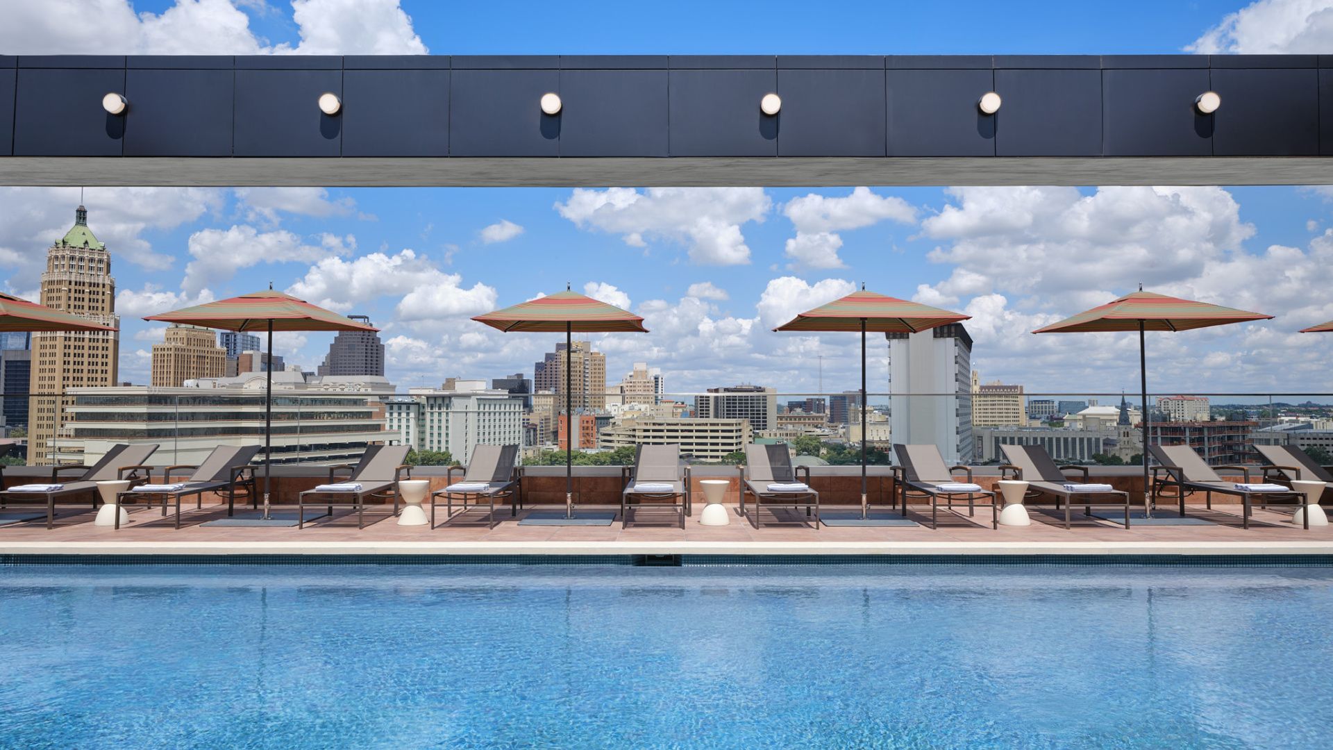 Rooftop pool with lounge chairs and umbrellas