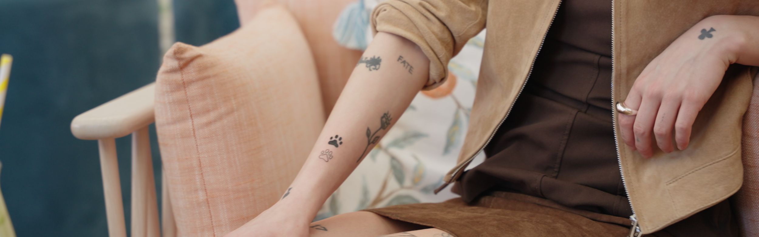 người phụ nữ có hình xăm đang ngồi trên chiếc ghế dài