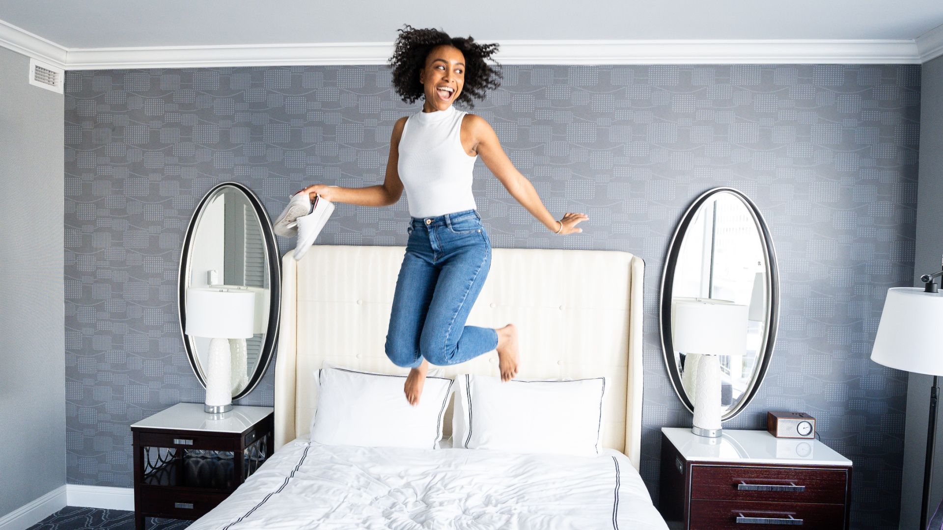 woman jumping on a bed with glee