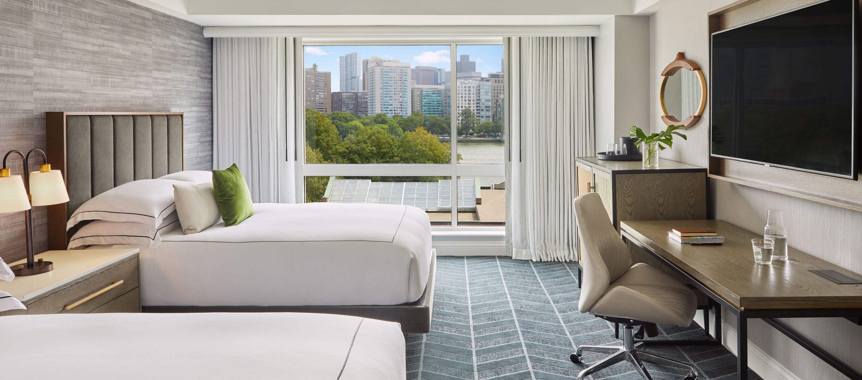 urban guestroom with floor to ceiling windows and city views