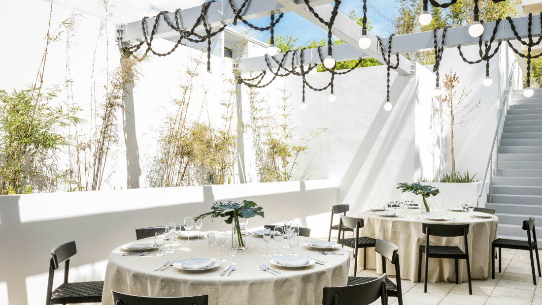 a casual outdoor dining area next to a hotel